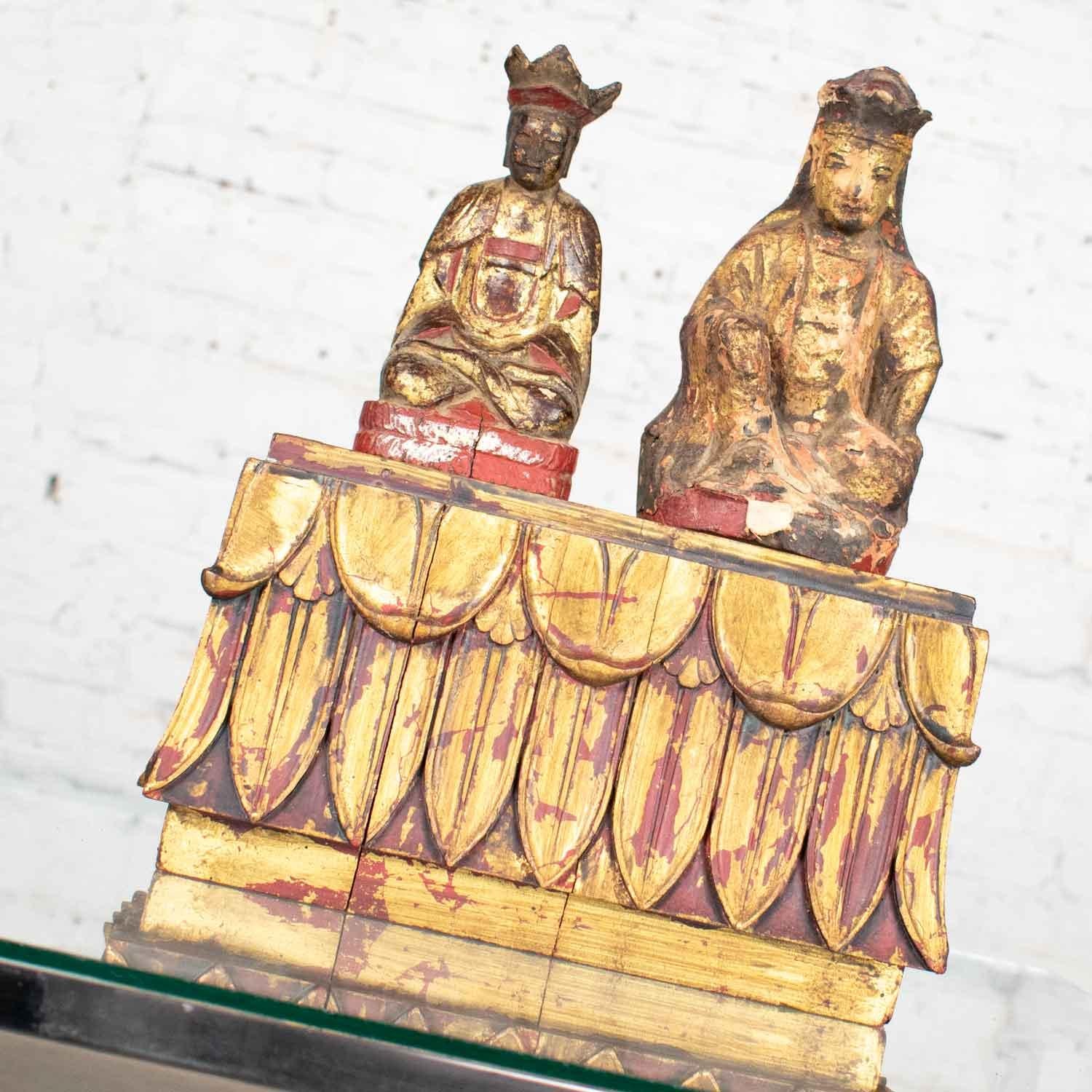 Fabulous pair of Buddha and stand comprised of hand carved wood. Hand painted red underlay has been gilded. Wonderful vintage condition with age appropriate nicks and chips. Crown on smaller Buddha is broken on the right side and he has a slight