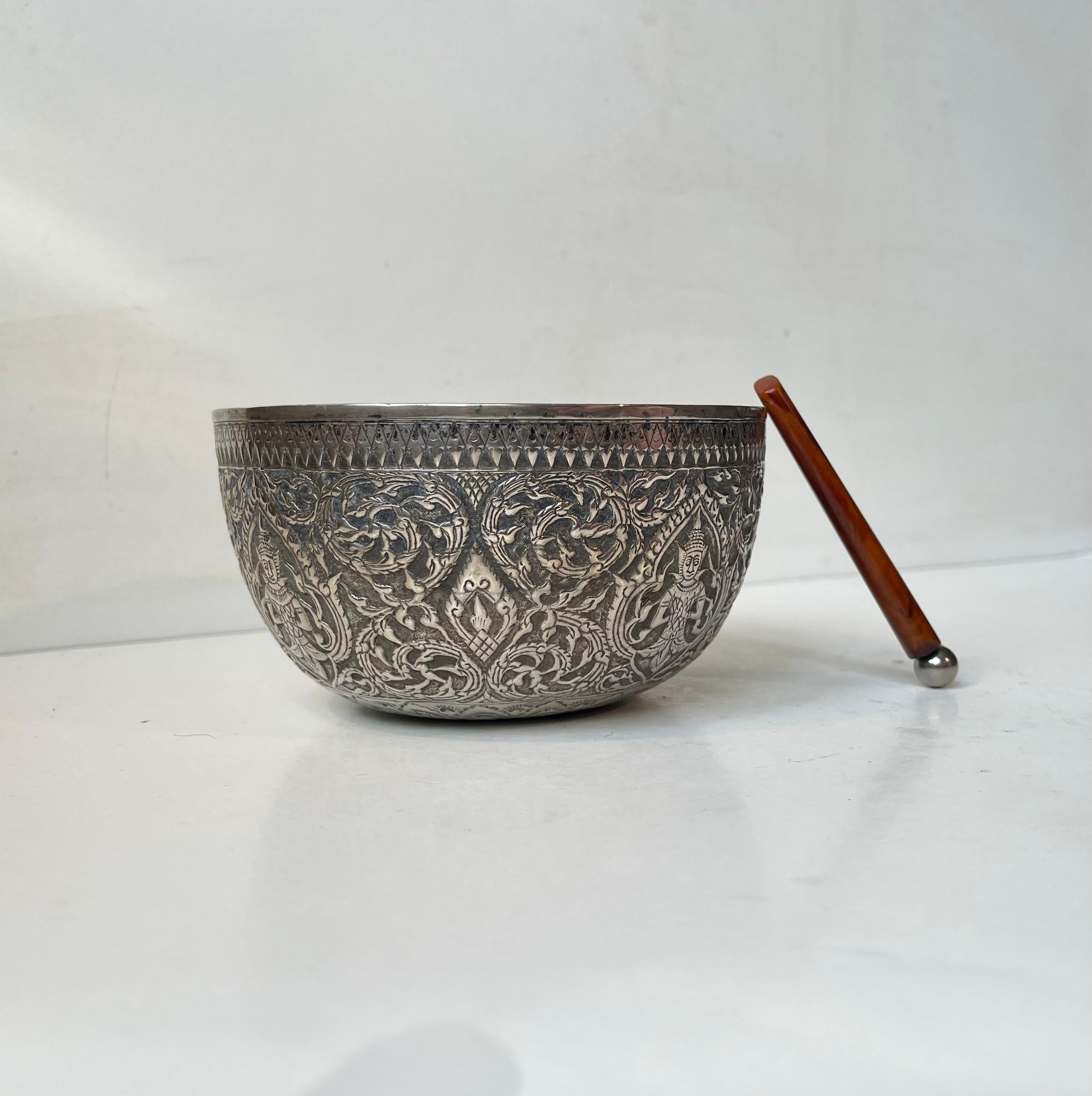 East Asian singing bowl hand-carved and decorated excessively in repoussé silver (850/1000). Buddhist theme high-lighted with floral impression everywhere you look. It has a beautiful tone when stroken that prolongs and mellows out nicely. Good size