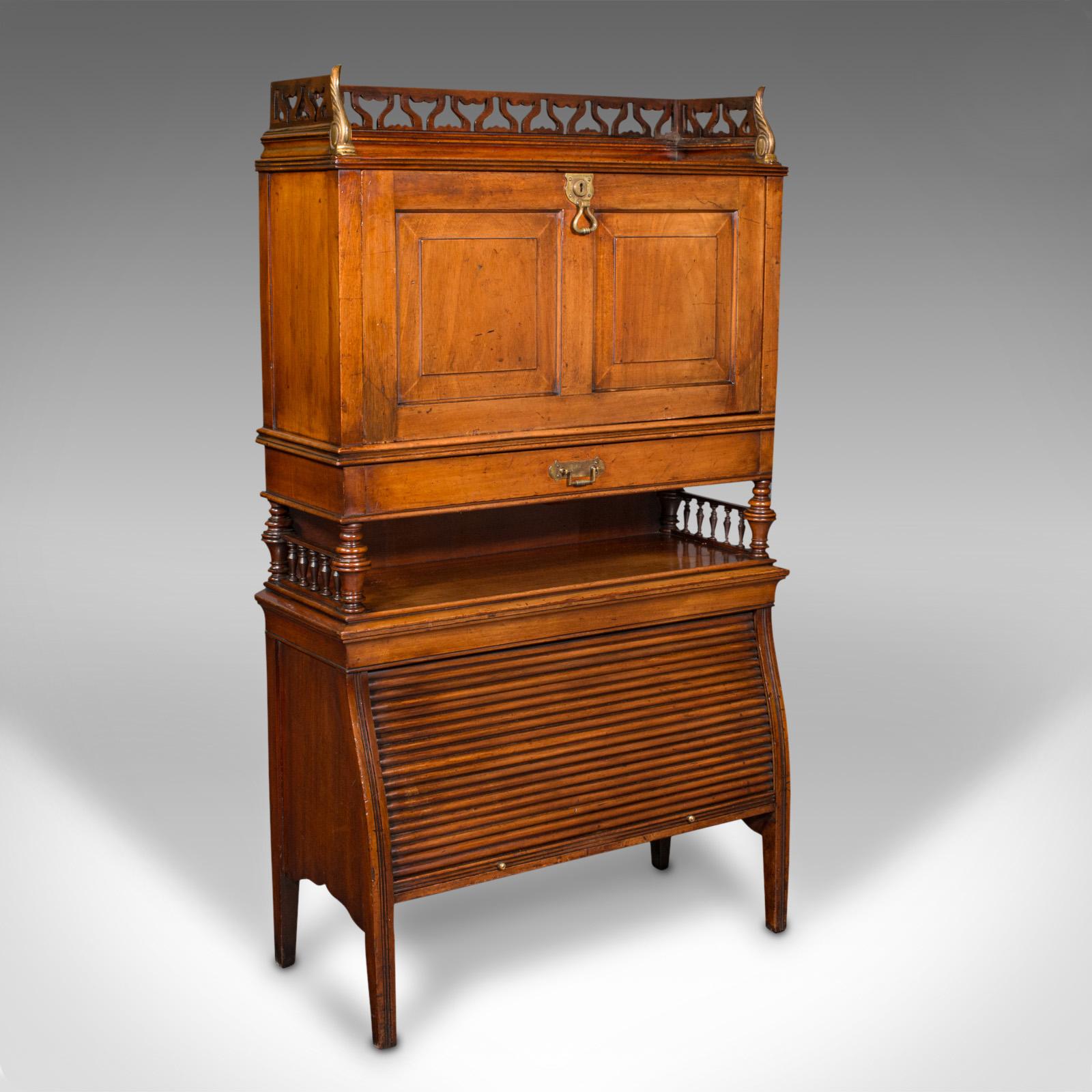 This is an antique bureau cabinet. An English, walnut drop-front writing desk with tambour, dating to the Edwardian period, circa 1910.

Graced with superb colour and of usefully compact stature
Displays a desirable aged patina and in good