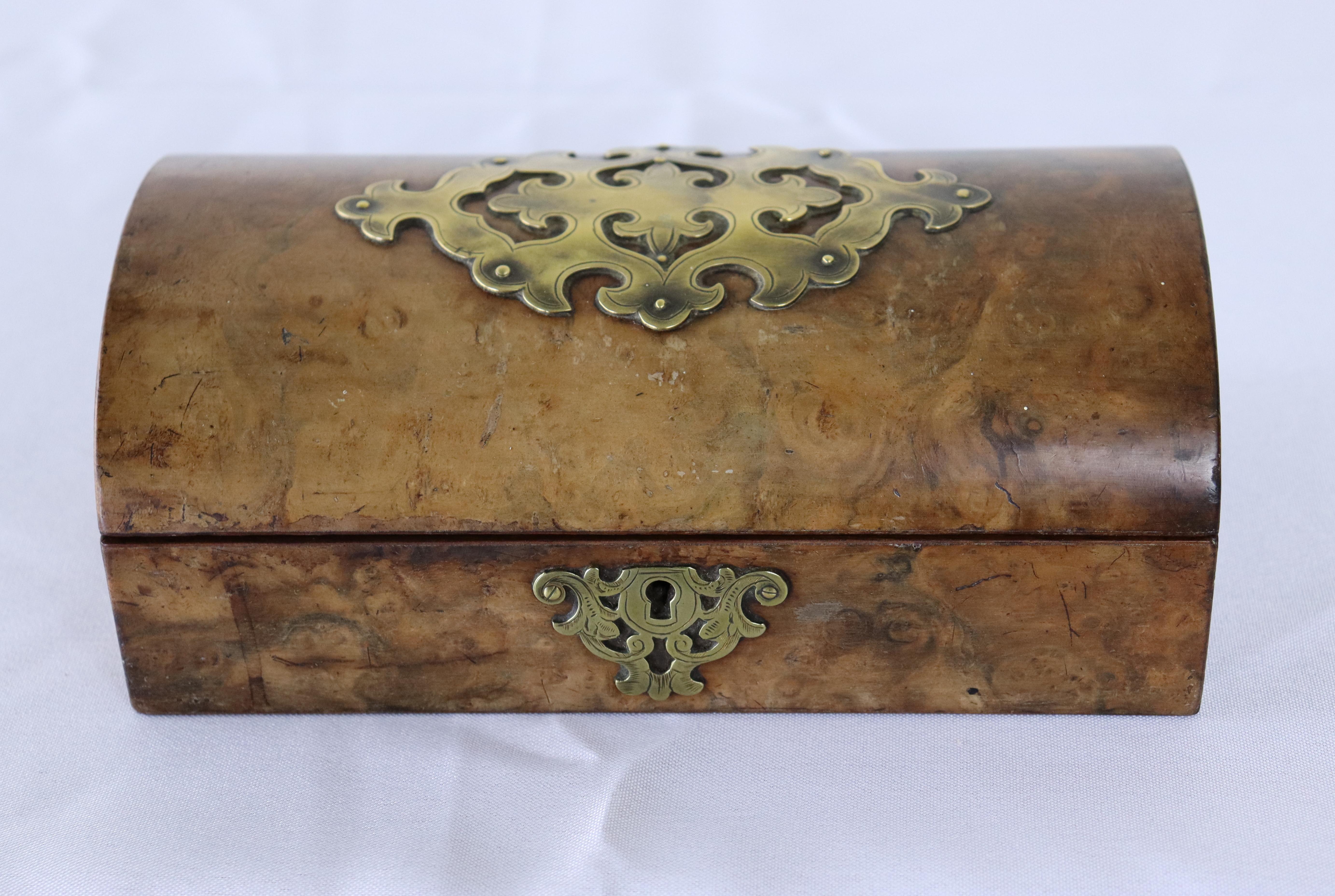 A dome shaped English jewelry box fashioned out of burr walnut.  The brass decoration is in very good condition.