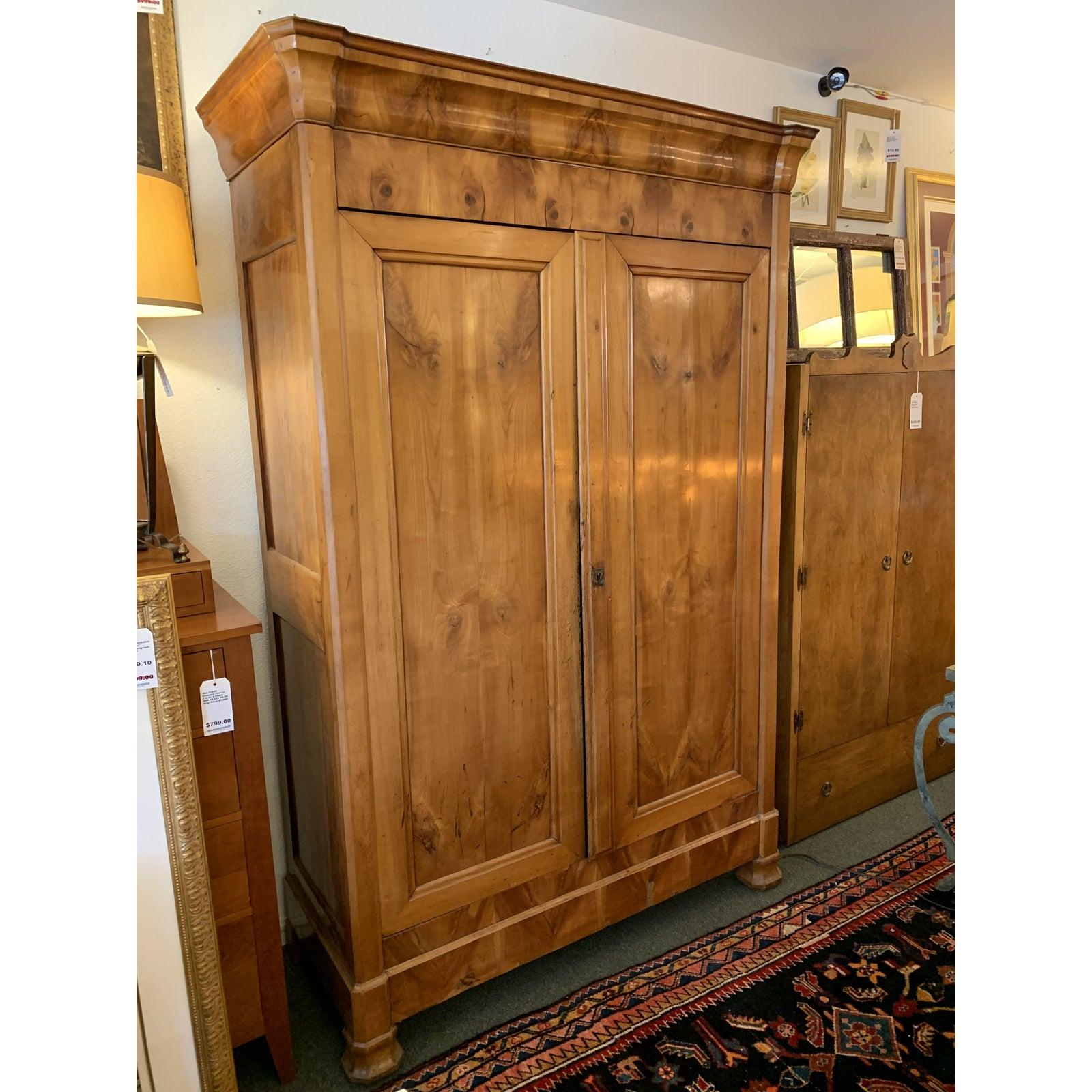 A beautiful Antique Armoire. Beautiful burls draw the eye to the beautiful woodgrain and elegant Silhouette. Two large doors swing open to reveal expansive storage and adjustable shelves and clothes rod. No key available.