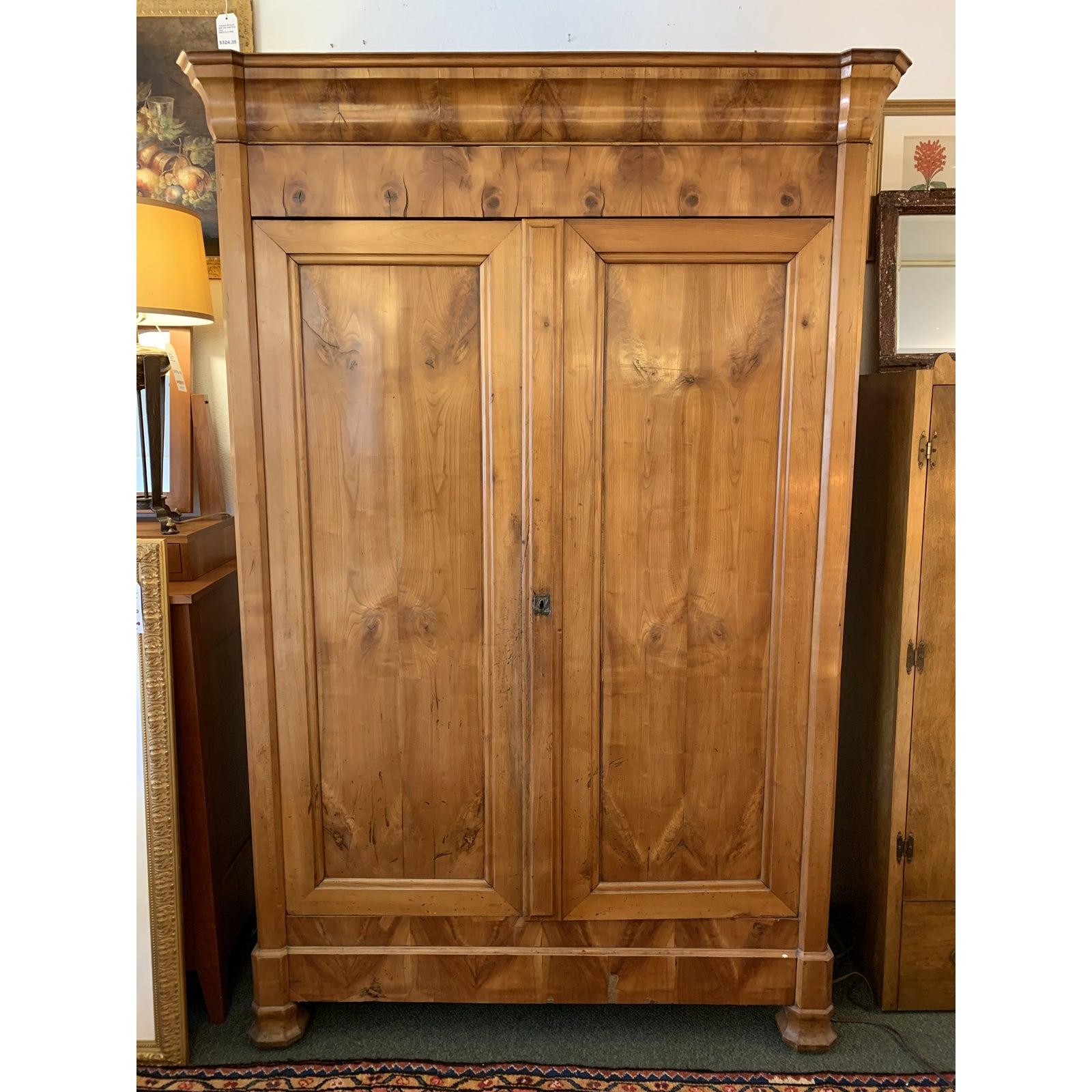 A beautiful antique armoire. Beautiful burls draw the eye to the beautiful woodgrain and elegant silhouette. Two large doors swing open to reveal expansive storage and adjustable shelves and clothes rod. No key available.