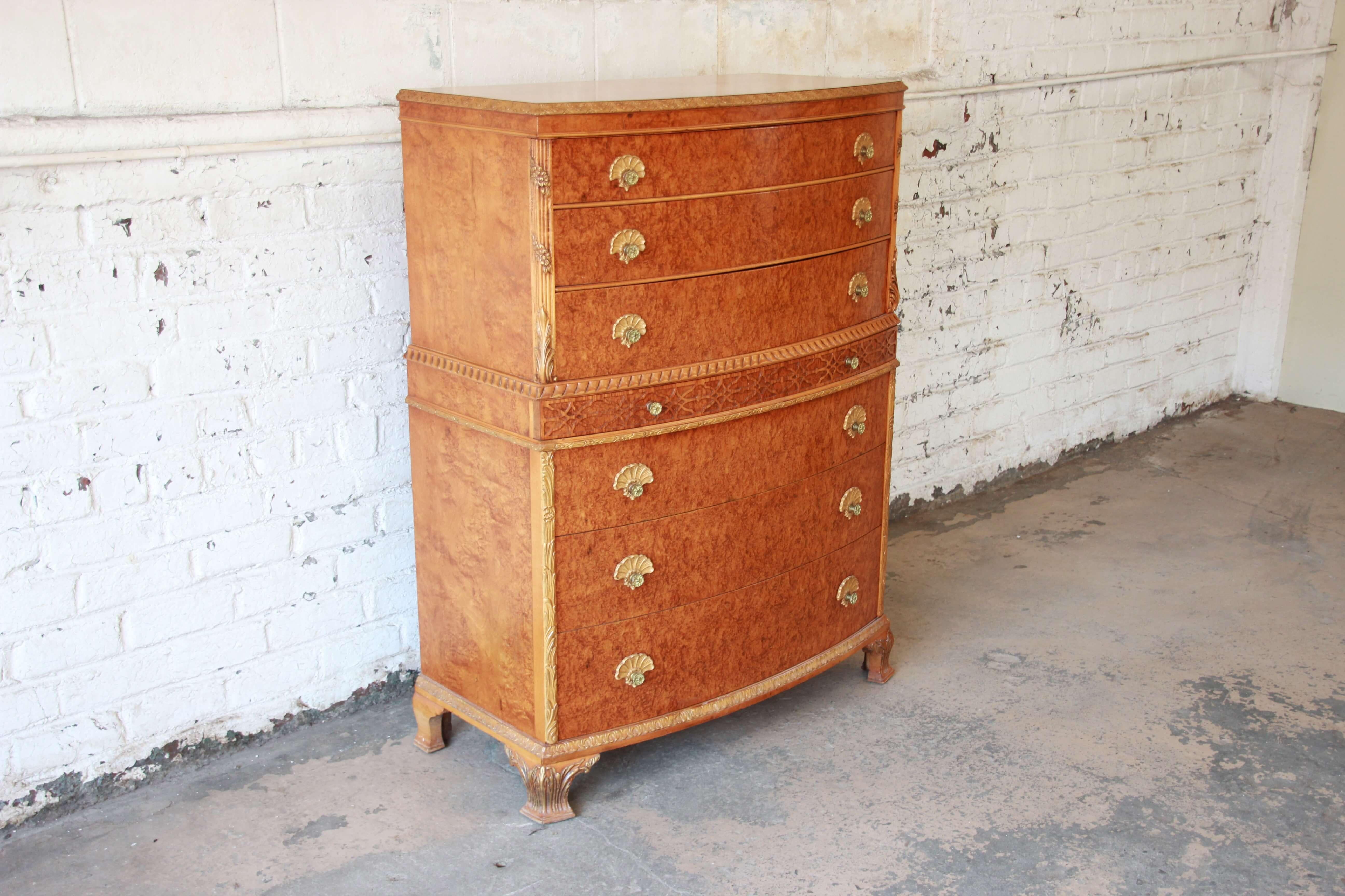 Offering a very nice and elegant antique burled French carved highboy dresser by Romweber. This amazing piece features seven smooth sliding drawers with brass pulls with shell accents. The burl finish is stunning along with the French carved