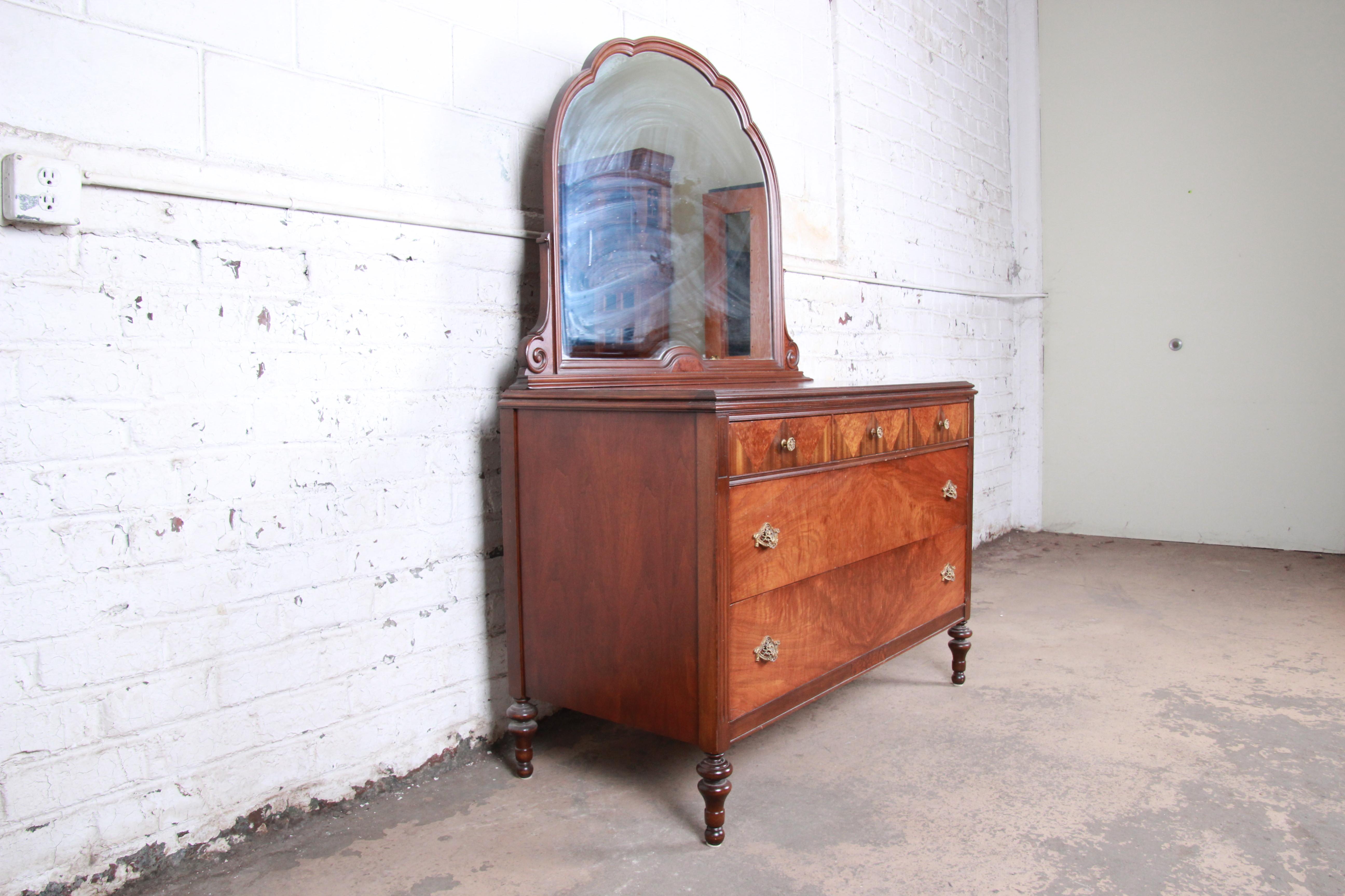 An exceptional antique burled walnut five-drawer dresser with mirror

Attributed to Baker Furniture

USA, circa 1920s

Burled walnut and brass hardware and mirror

Measures: 50