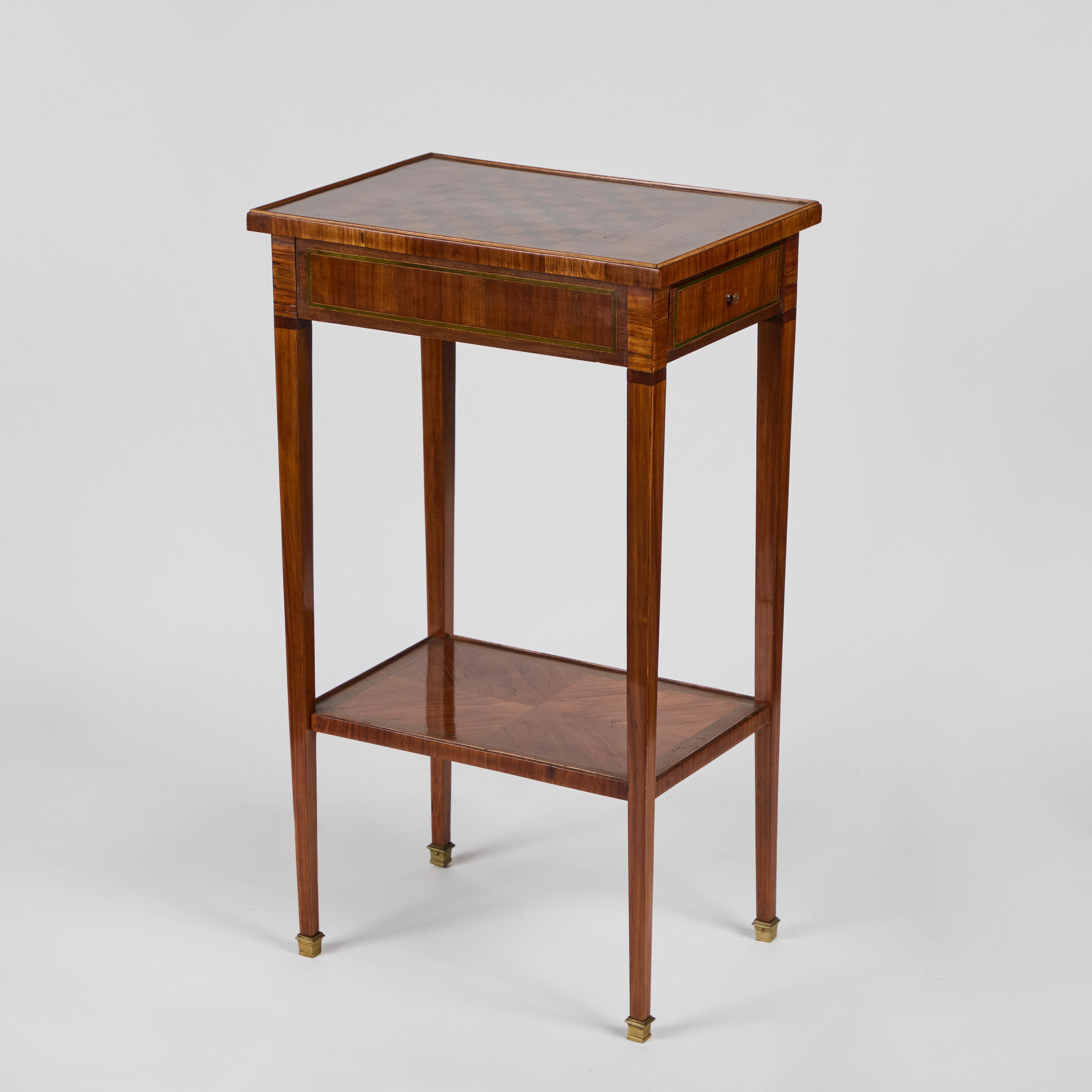 Charmante table d'appoint avec plateau en damier incrusté en noyer ronce et peuplier, dotée d'une étagère inférieure,  de l'intérieur de la pochette en cuir,  tiroir et sabots en bronze.
