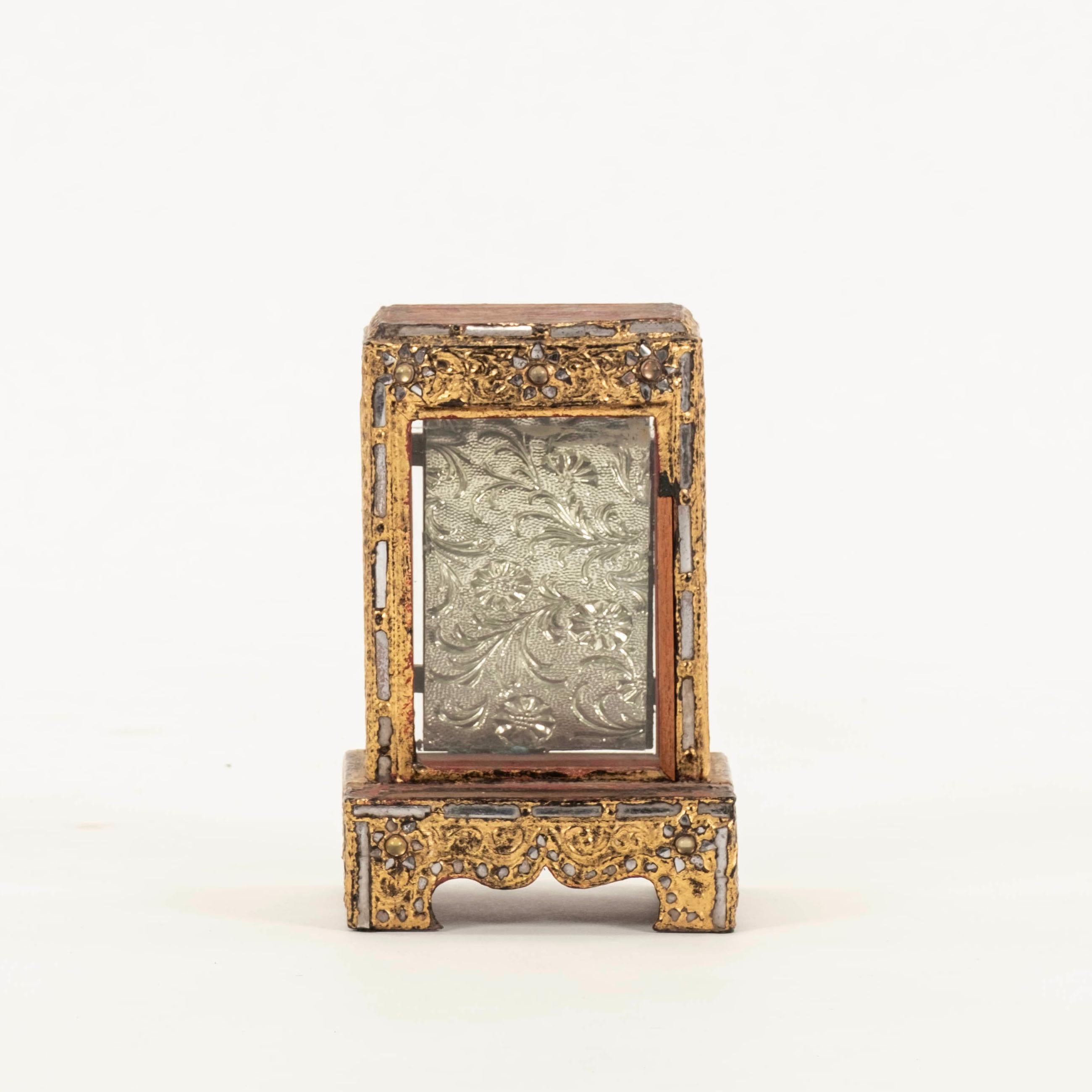 Burmese hand-carved Buddha temple shrine featuring gilded wood, glass panes, and a metal repoussé back.

Visit our other 1STDIBS storefront Moxie Interiors to shop a vast array of exceptional home furnishings!