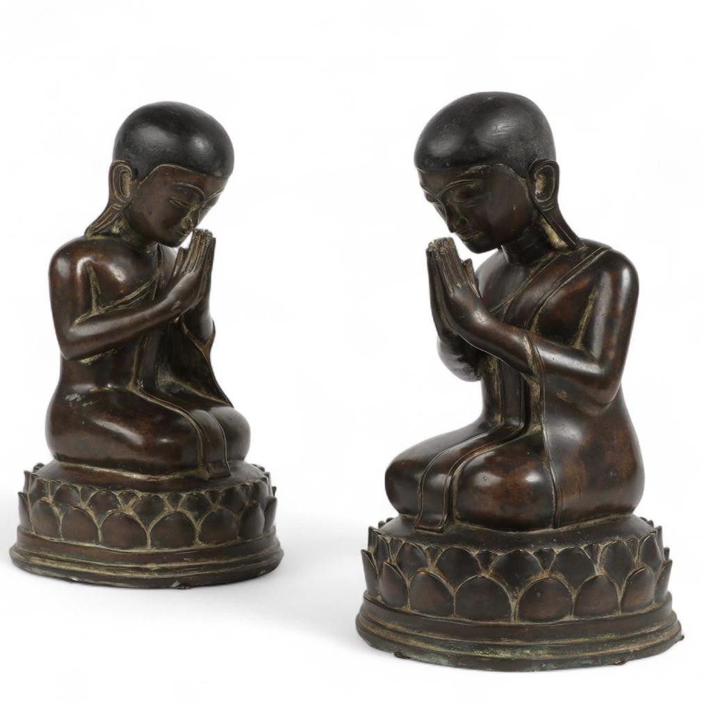 Antique Burmese Buddhist Opposing Pair of Bronze Monks, Shan States. The figures are often referred to as Moggollana and Sariputta. Two smooth bronze kneeling male figures rendered as having thin draped robes. The earlobes are elongated and the
