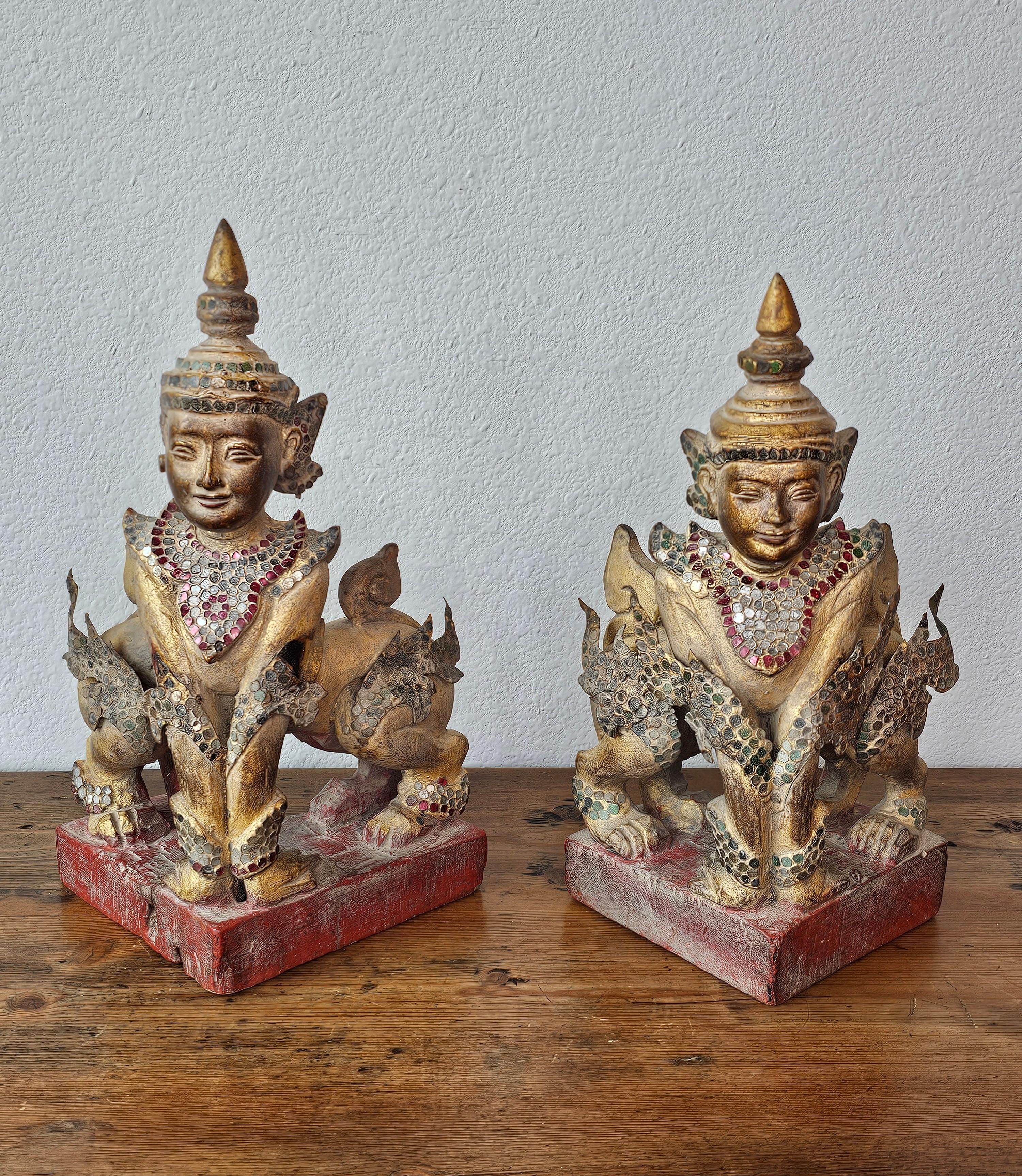 A whimsical near pair of antique Burmese Mandalay crowned and jeweled parcel gilt wooden mythical Manuthiha figures.

Hand-carved in Burma (present day Myanmar) in the late 19th / early 20th century, the exceptional Southeast Asian Buddhist figural