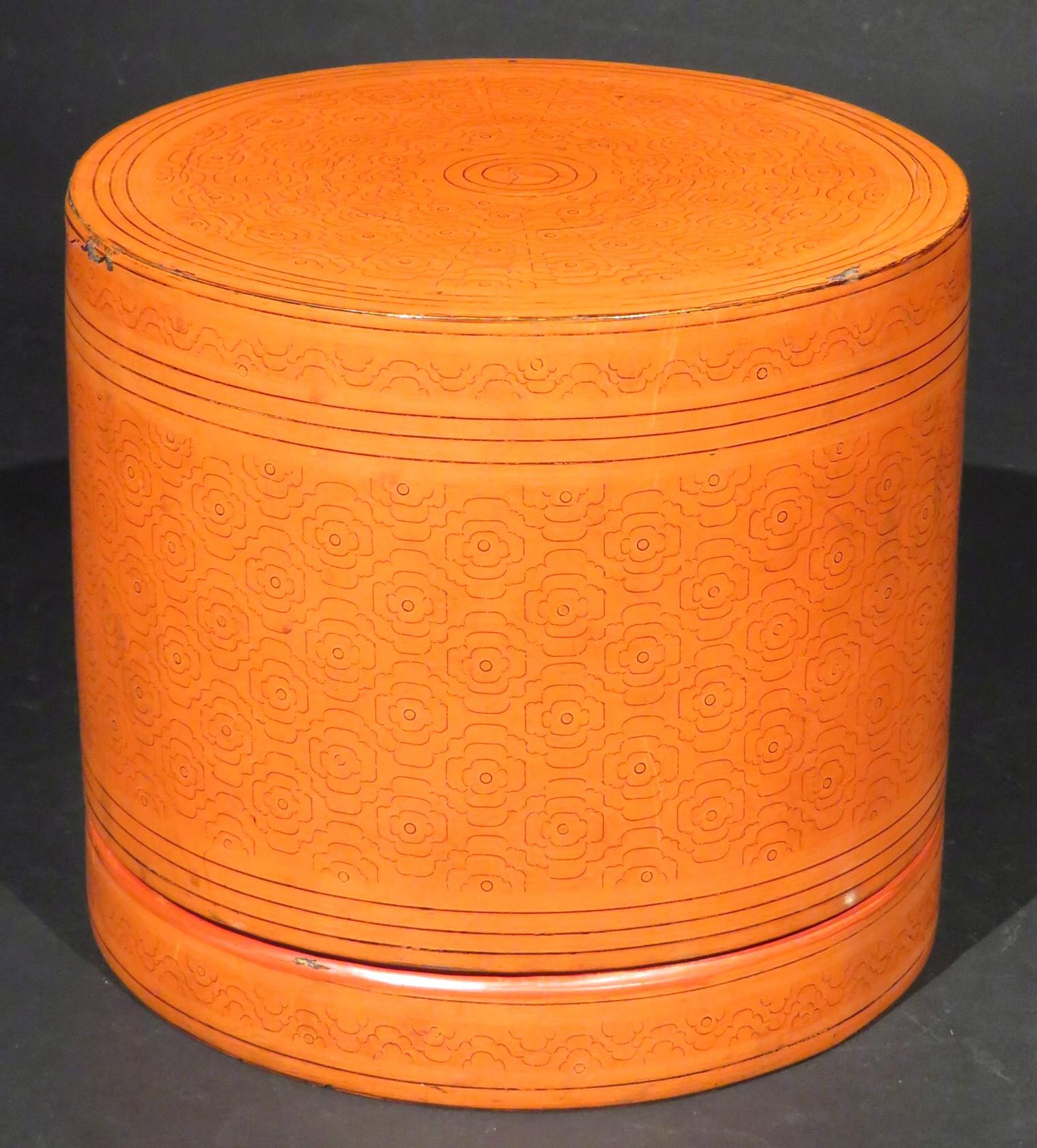 The vermillion lacquered cylindrical body decorated overall with repeating bands of curvilinear geometric motifs, the cover lifting to reveal both of its original trays intended to hold betel leaves, along with ingredients used for making betel