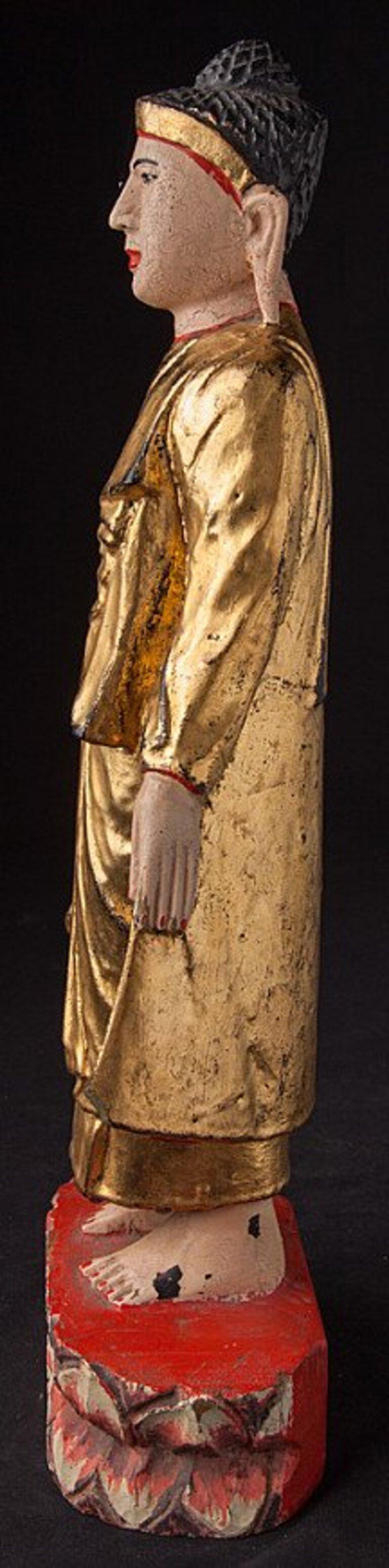 Cette statue de Bouddha antique en bois est une pièce de collection vraiment unique et spéciale. D'une hauteur de 43 cm, d'une largeur de 15 cm et d'une profondeur de 8,5 cm, elle est réalisée en bois et dorée à l'or fin 24 krt. Les détails
