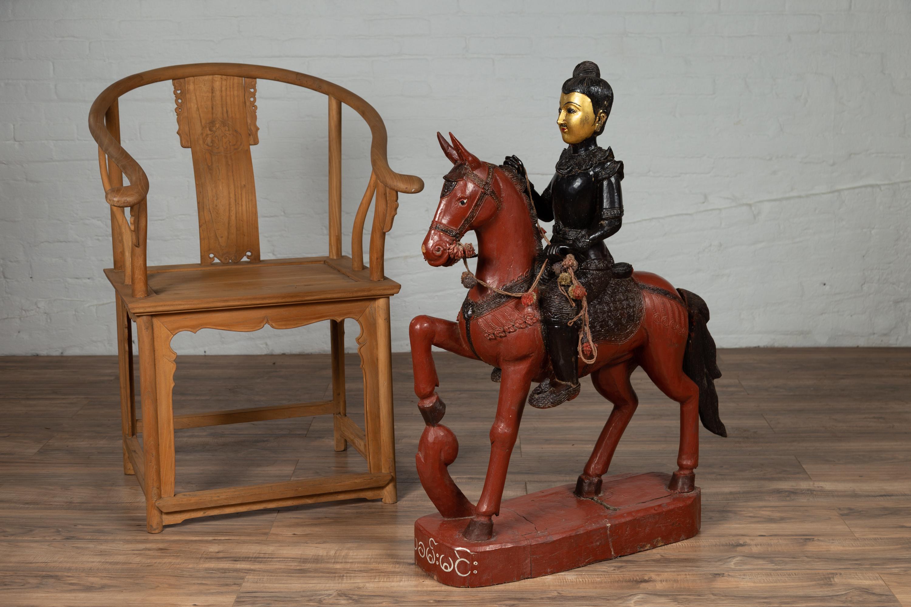 A vintage Burmese polychrome wooden statue from the mid-20th century, depicting a warrior on a horse. Born in Burma during the mid-century period, this striking carved wooden statue features a warrior sitting proudly on his brown horse. The