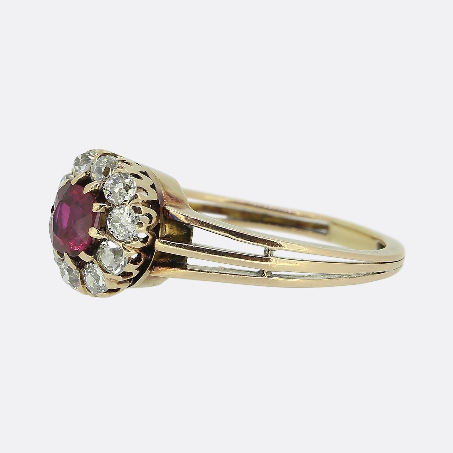 Here we have a Victorian cluster ring featuring a gorgeous deep pinky red ruby of Burmese origin. This principal stone sits slightly risen in a 10 clawed setting whilst being surrounded by a frame of round faceted old mine cut diamonds, each with a