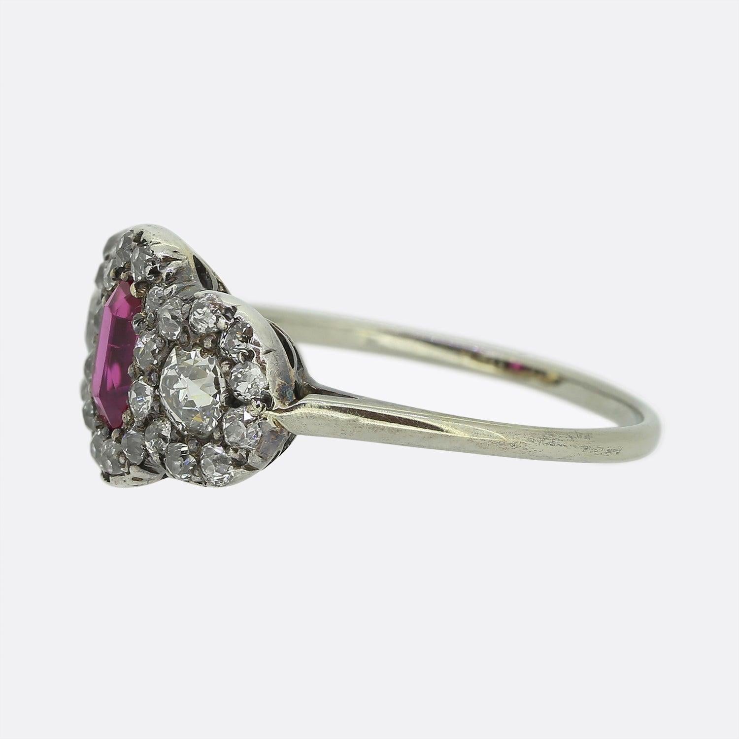 Ecco un meraviglioso anello antico con rubino e diamante a grappolo risalente al periodo edoardiano. Al centro del pezzo troviamo un rubino naturale birmano di forma ovale allungata che mostra una giocosa tonalità di colore rosa. Questa pietra
