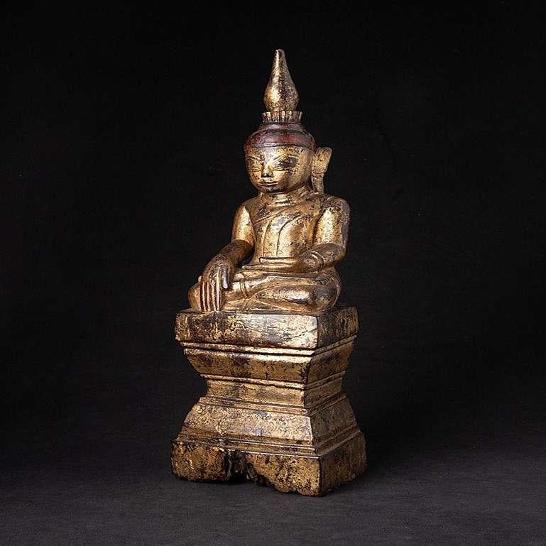 Material: wood
53 cm high 
15,3 cm wide and 12 cm deep
Weight: 2.216 kgs
Gilded with 24 krt. gold
Shan (Tai Yai) style
Bhumisparsha mudra
Originating from Burma
18th century
With Burmese inscriptions in the base