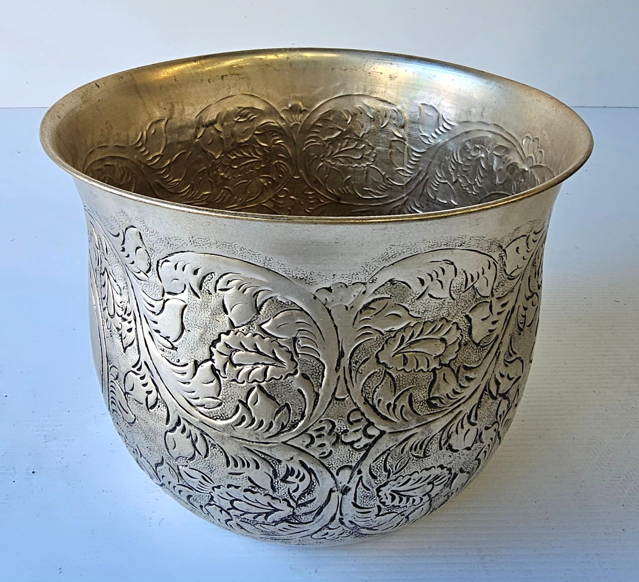 A 19th Century Burmese silver repousse bowl. The bowl is decorated with repoussé work, a technique where the metal is hammered from the reverse side to create a raised design. 
The design features floral and foliage patterns. 
These bowls were