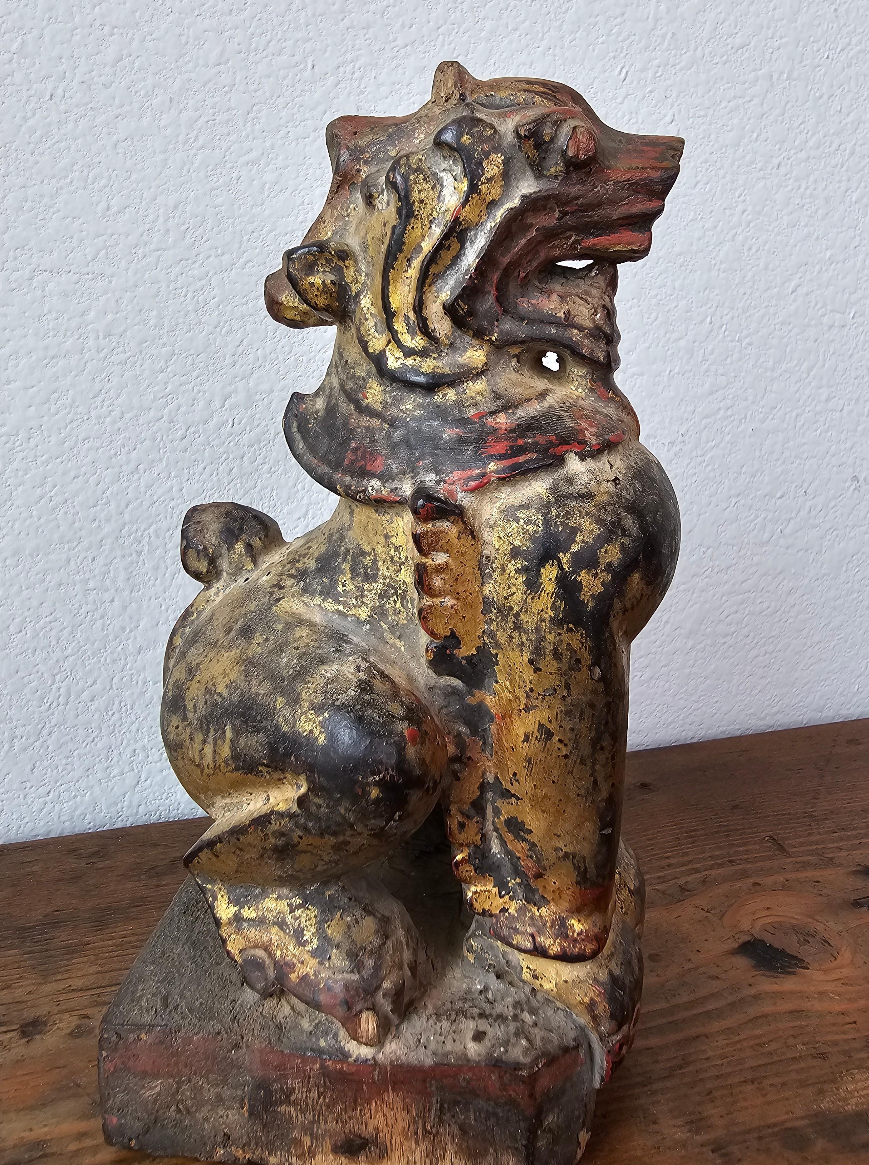 A primitive antique Southeast Asian Buddhist carved qilin foo dog temple guardian figure. 

Hand carved in Burma, 19th century or earlier, depicting the stylized lion mythical beast, rising on integral platform base, with remnants of original parcel