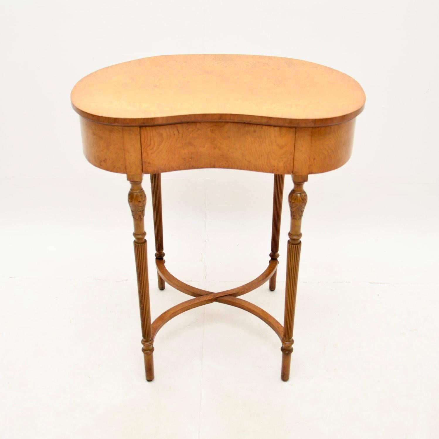 A quite unusual and beautiful antique burr elm kidney shape side / writing table. This was made in England, it dates from the 1920-30’s.

It is of superb quality, the kidney shaped top has a single drawer and stands on fluted tapered legs with cross
