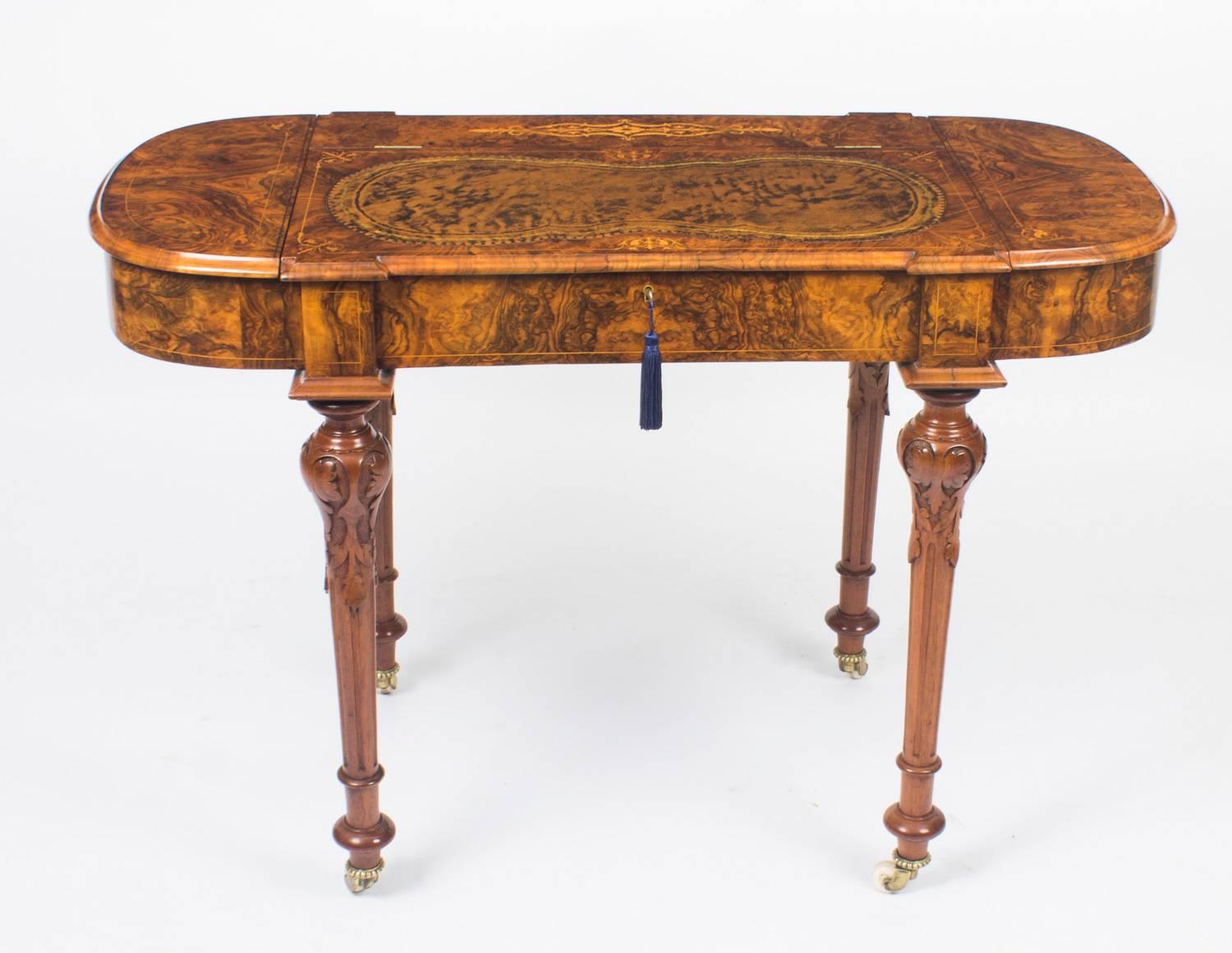 An elegant antique English Victorian burr walnut and marquetry writing desk, circa 1870 in date.

The top features delicate foliate marquetry with a shaped chocolate brown gold tooled leather inset, which lifts up to reveal a large space for