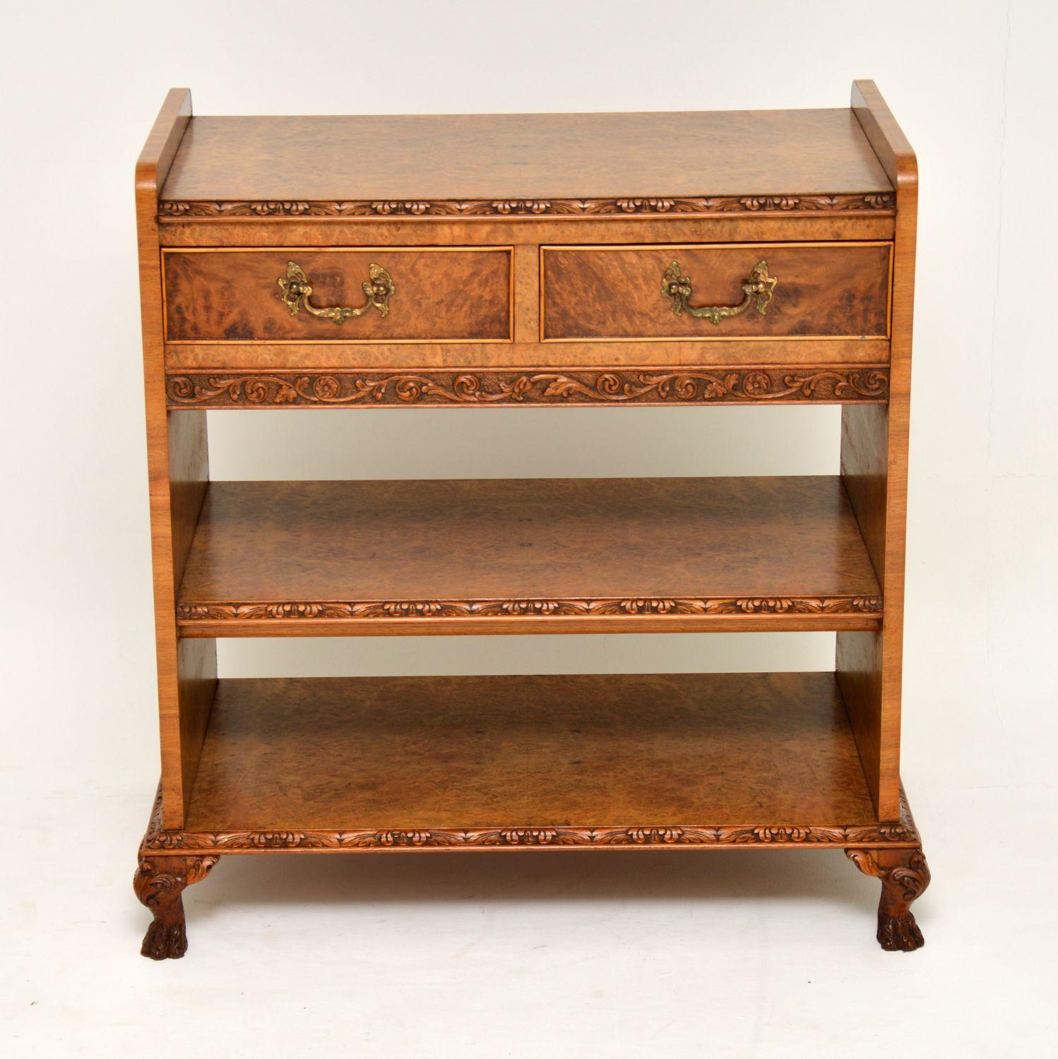 Unusually designed antique burr walnut server table with two open shelves below & some very fine carvings. It’s in excellent condition, having just been French polished & dates to circa 1920s-1930s period. This cabinet has a wonderful mellow color &