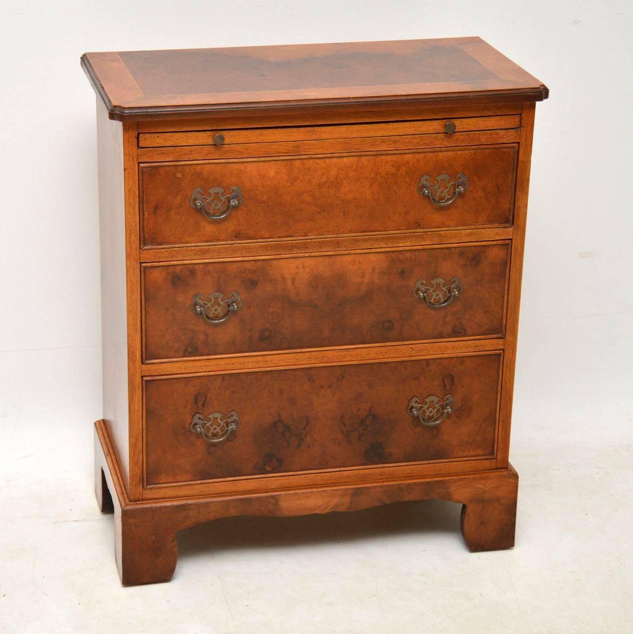 Small antique burr walnut bachelors chest of drawers with a brushing slide and sitting on bold bracket feet. It has lovely figuring in the wood all over and a lovely warm color too. The top is cross banded and the graduated drawers have the original