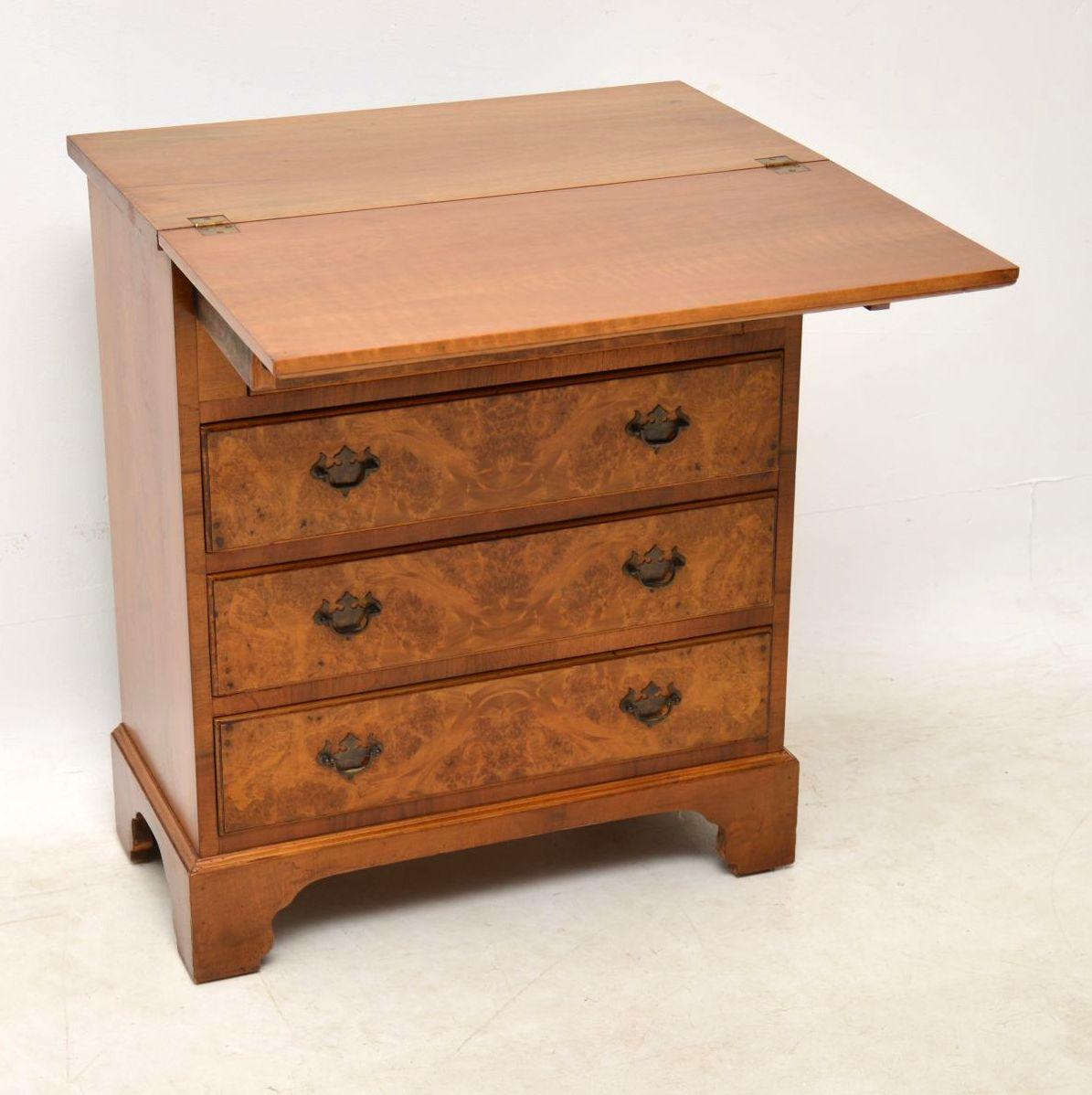 Antique burr walnut bachelors chest with a fold over top section that’s supported by two pull-out loafers. This chest has beautifully patterned burr walnut veneers, original brass handles and sits on bracket feet. This chest of drawers date from