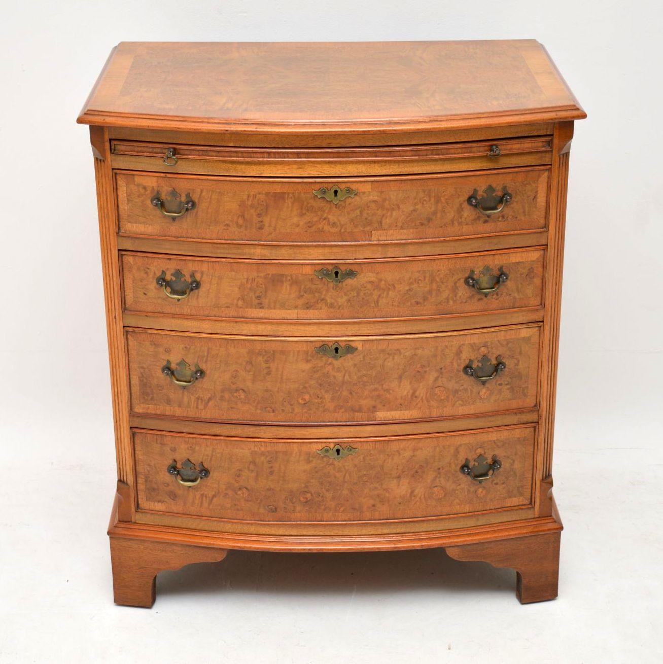 Small antique burr walnut bow fronted chest of drawers on bracket feet, with reeded canted corners and a brushing slide. It has a cross banded top, four graduated drawers also cross banded with original brass handles, locks and escutcheons. This
