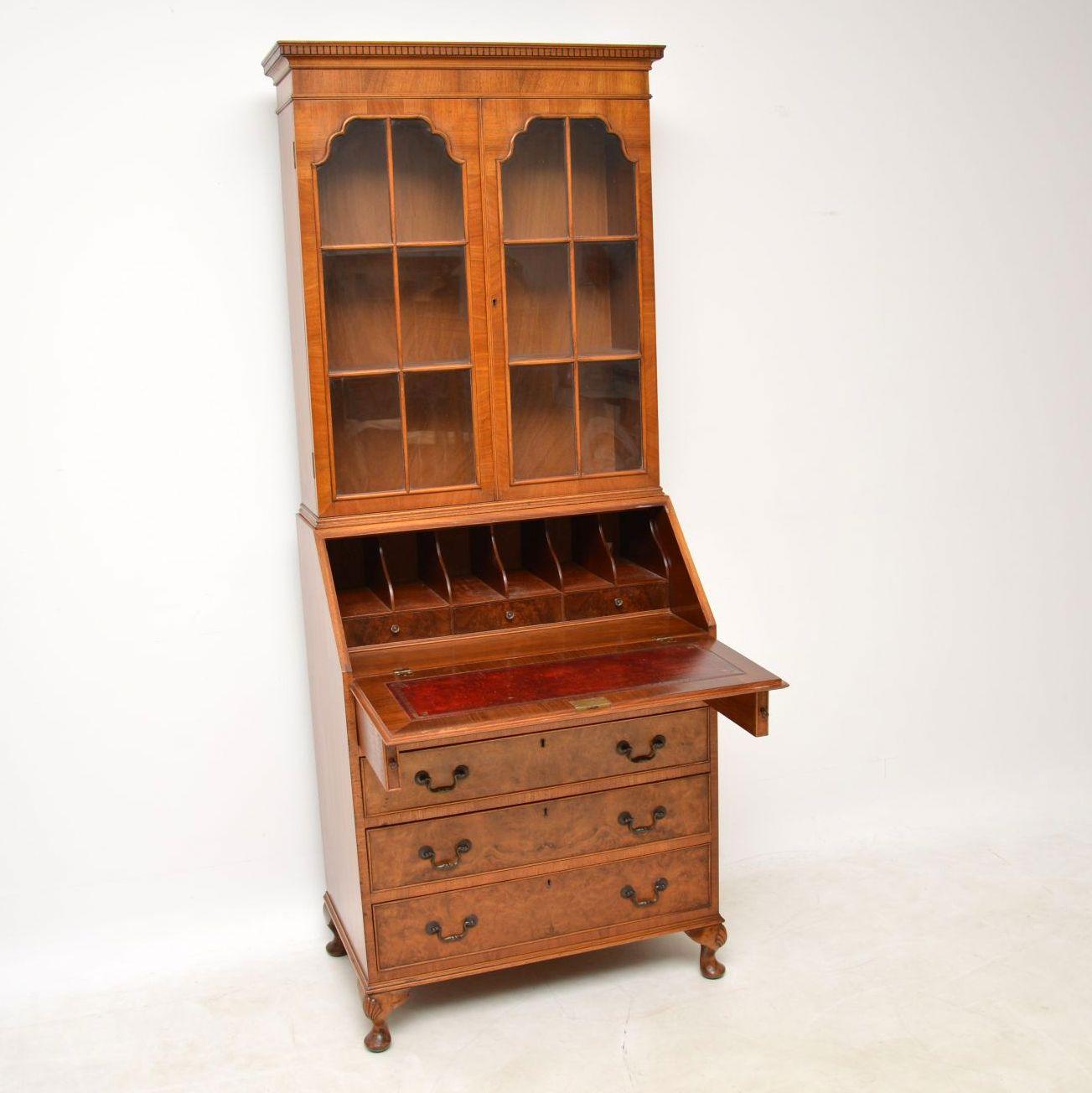 Antique burr walnut bureau bookcase with an astral-glazed bookcase section & bureau below, sitting on carved Queen Anne legs. It has a dental frieze under the cornice & two doors below with adjustable shelves. The bureau has a nice interior with