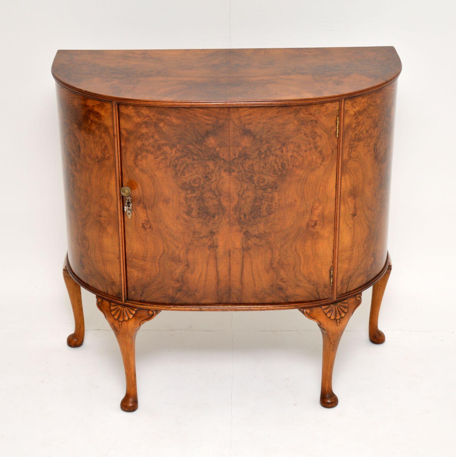 This antique burr walnut cabinet is a very useful item, because it takes up no more room than a side table, but has lots of storage inside.

It’s bow fronted and sits on solid walnut legs that are carved on the tops. There is lots of storage