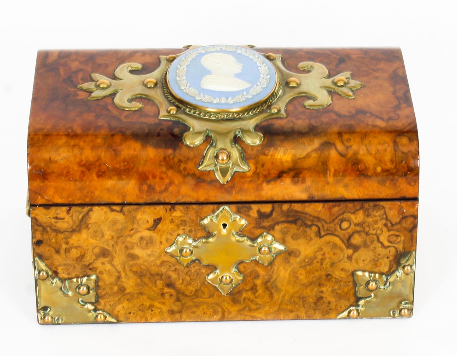 This is a lovely antique Victorian 19th century porcelain and ormolu-mounted burr walnut dome top casket, circa 1870 in date.
 
The casket has a superb inset scrolling brass cartouche inset with an oval Jasper Ware porcelain plaque of a gentleman