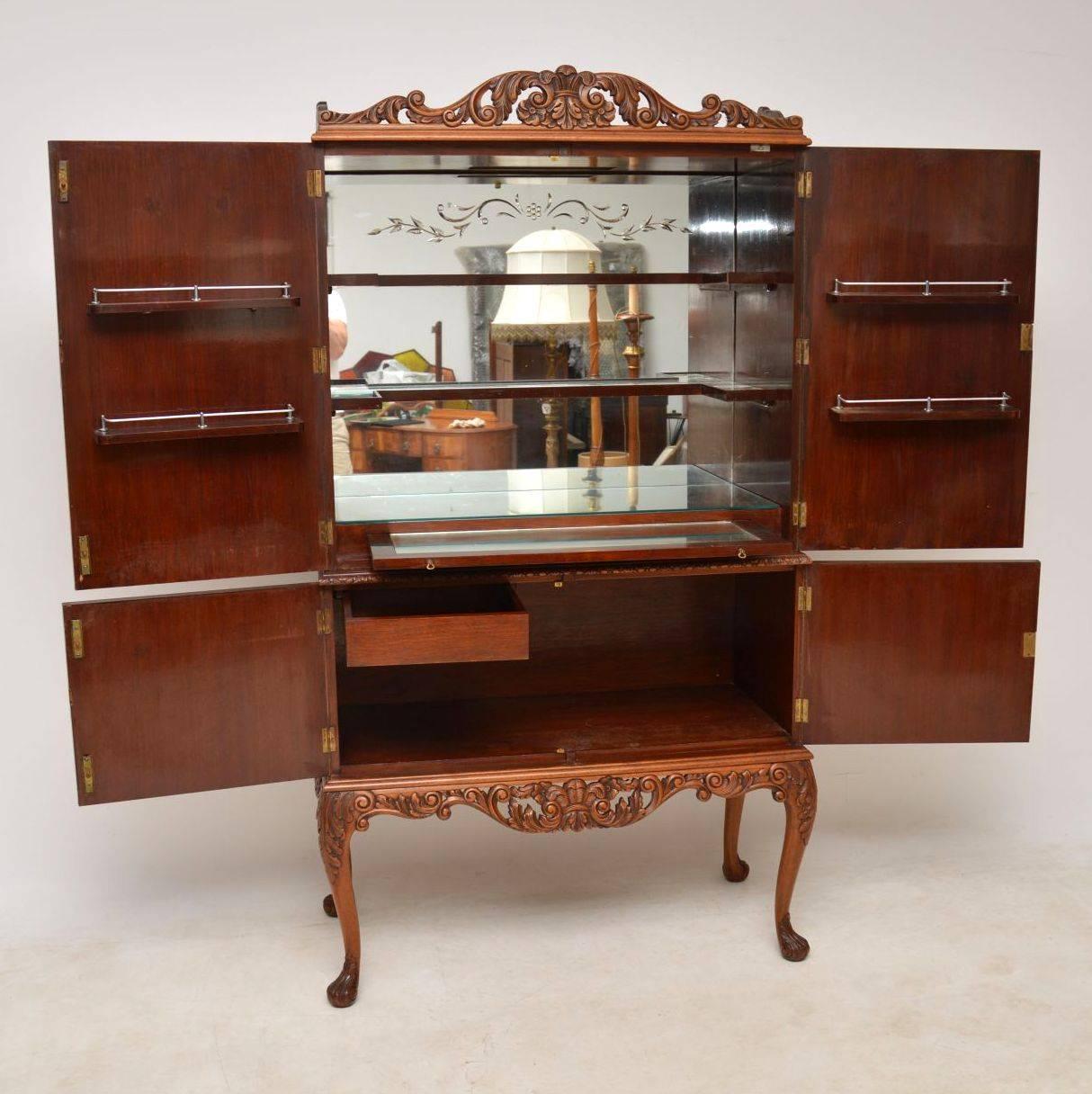 Very impressive antique Queen Anne style burr walnut drinks cabinet dating to circa 1920s period. The burr walnut veneers have wonderful patterns and are all-over the front and the sides. The hand carvings are also exceptional around the top, bottom
