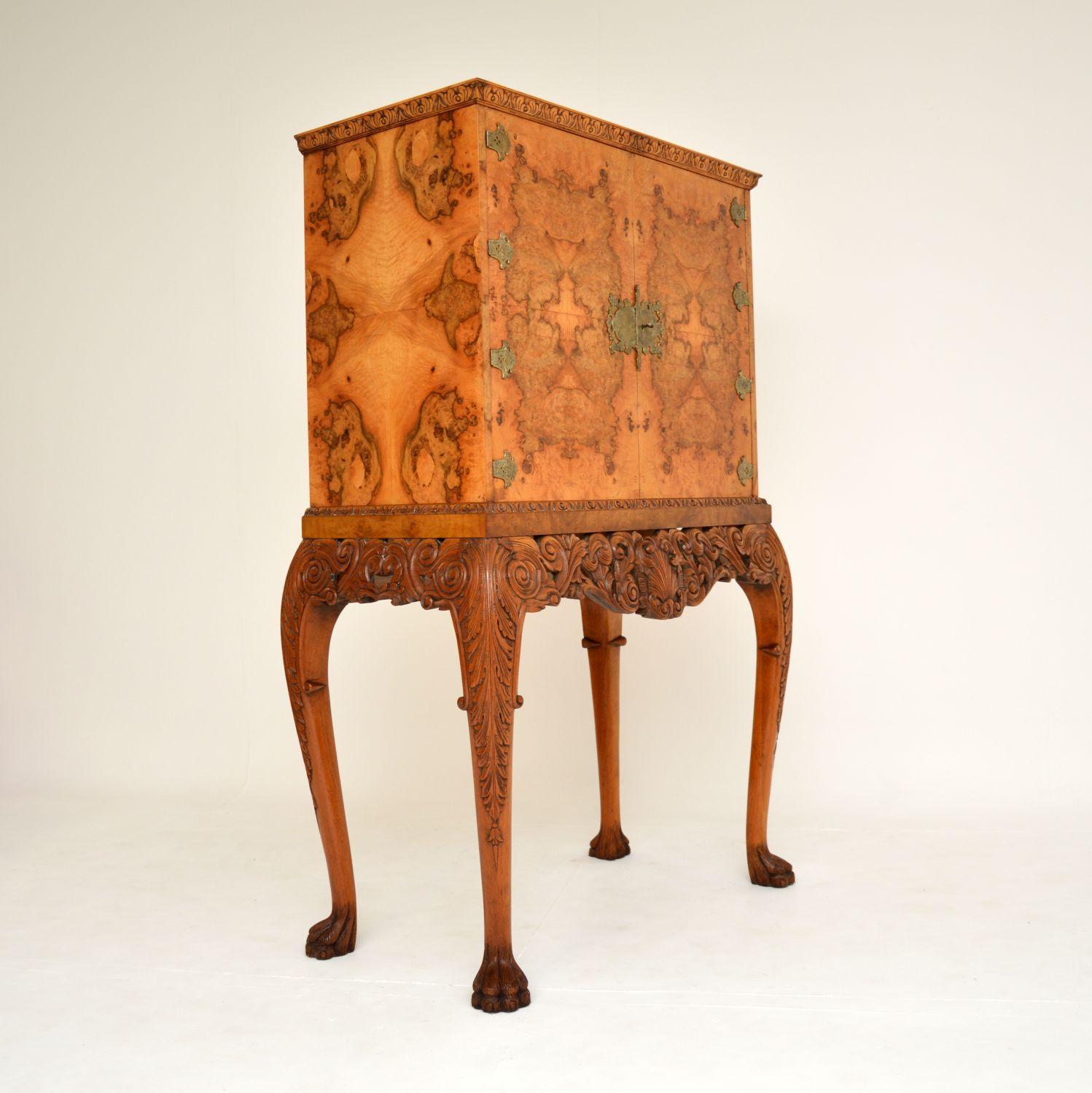 A stunning antique burr walnut cocktail cabinet in the Queen Anne style. This was made in England, it dates from around the 1920’s.

It is of superb quality, with gorgeous burr walnut grain patterns, crisp carving and fine ormolu mounts. The base