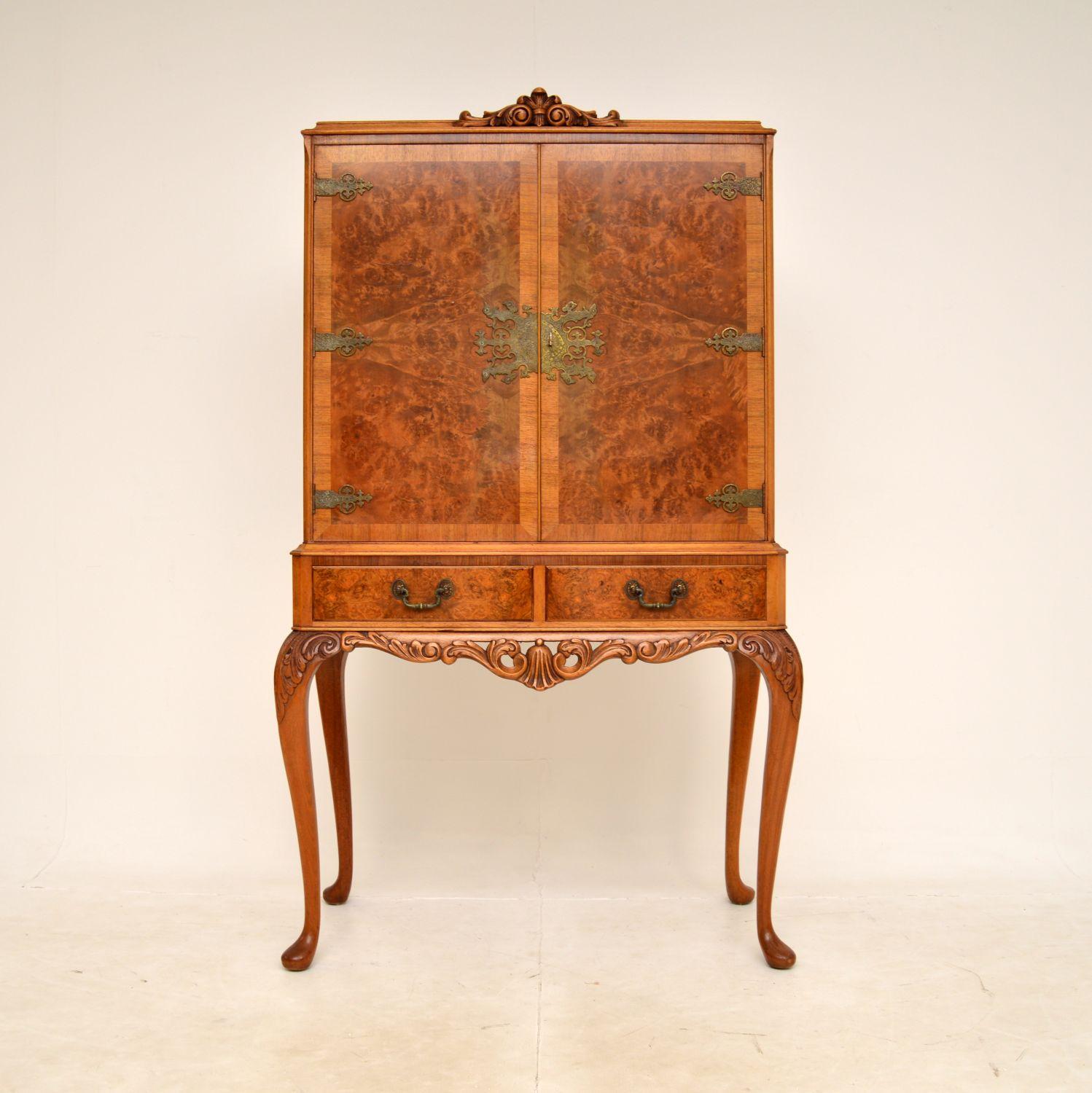 A beautiful antique walnut cocktail drinks cabinet in the Queen Anne style. This was made in England, it dates from around the 1930-1950s.

This is of superb quality, with stunning burr walnut grain patterns, crisp carving and high quality pierced
