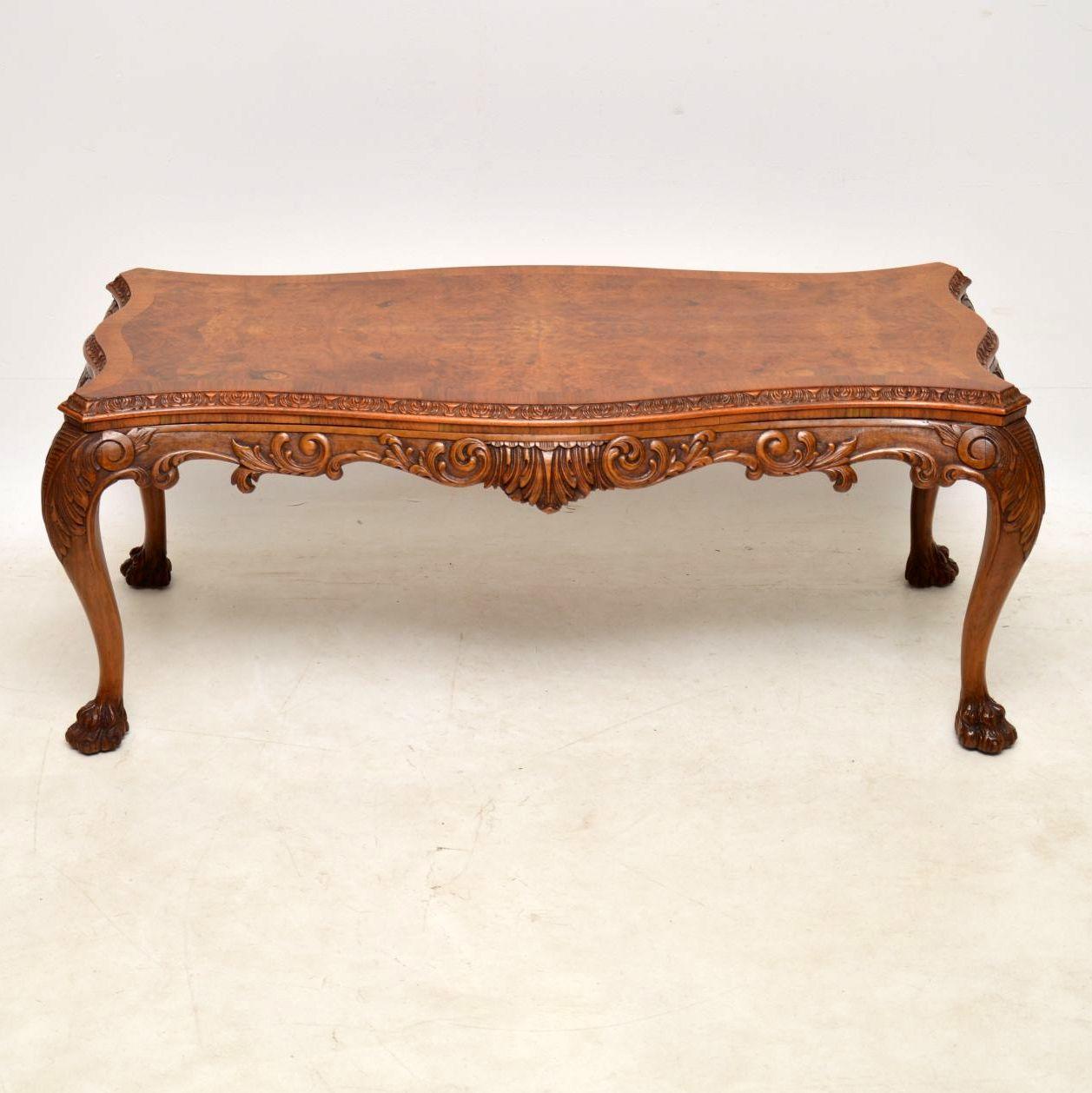 This very impressive antique walnut coffee table is of very high quality and has fabulous carvings all-over. Please enlarge all the images to appreciate this. The shaped top is burr walnut and is crossbanded. It’s carved all around the sides and the