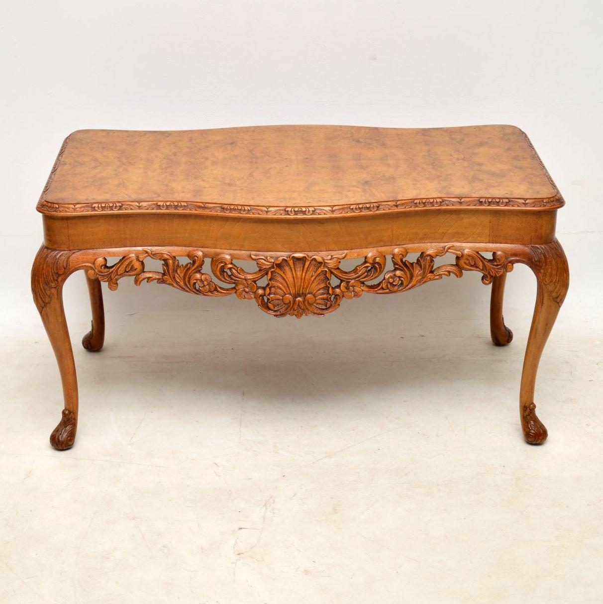 This antique walnut coffee table has a wonderful mellow color and is full of character. It is beautifully carved all over and the deep carvings between the legs are stunning. This coffee table is in good condition all over and dates from around the