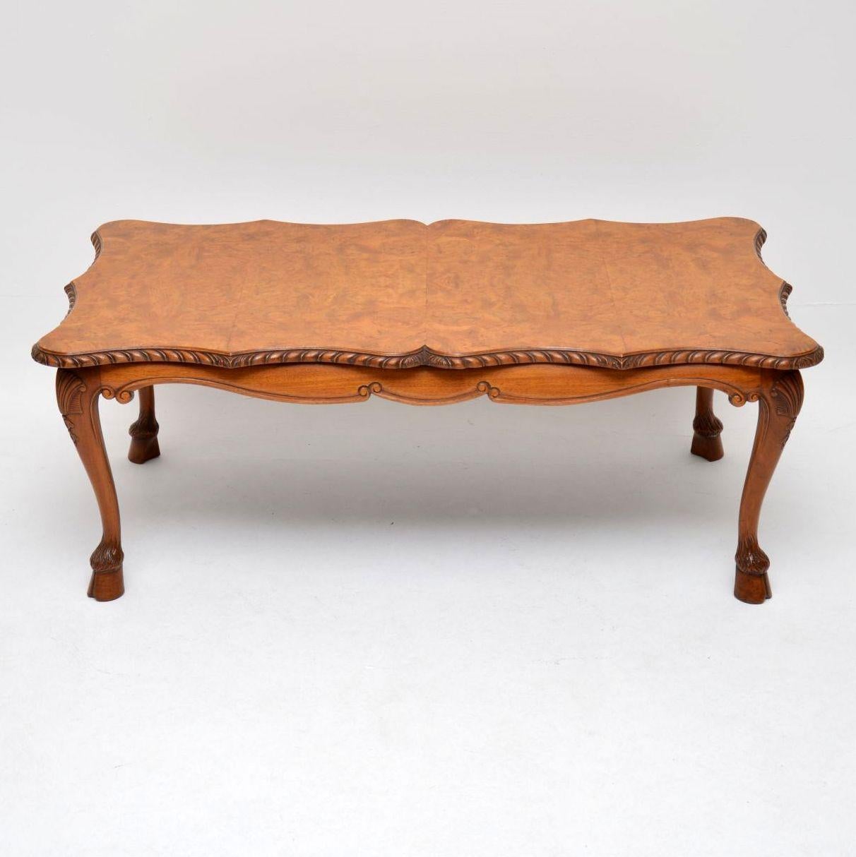 This antique walnut coffee table has a lovely mellow color and some exquisite features. It dates to circa 1920s-1930s period and is in excellent condition, having just been polished. The shaped top has a carved gadrooned edge, while the solid walnut
