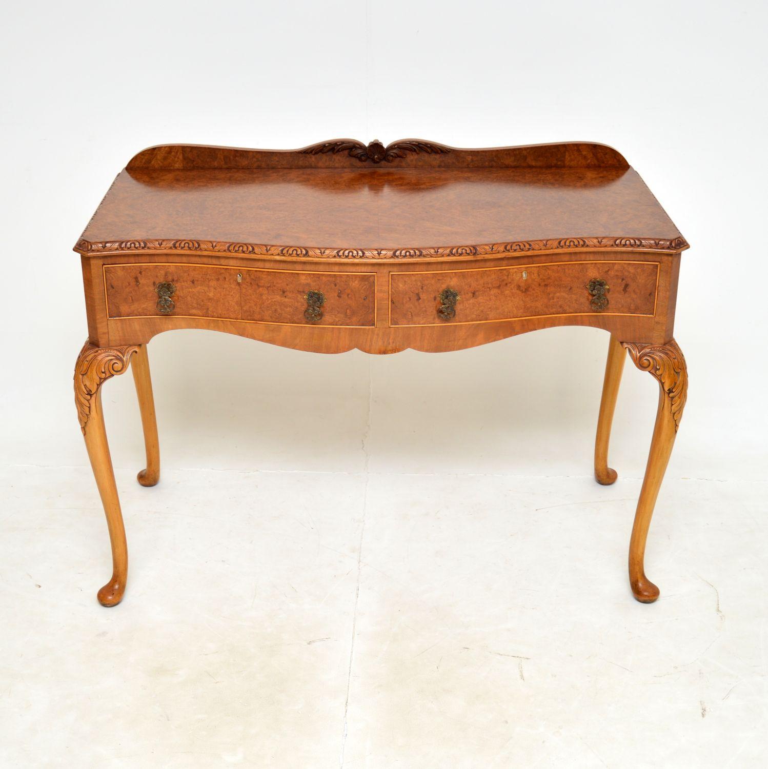 A superb antique burr walnut console server table in the Queen Anne style. This was made in England, it dates from the 1920-1930s.

The quality is outstanding, this has stunning burr walnut grain patterns and beautiful, crisp carving throughout.