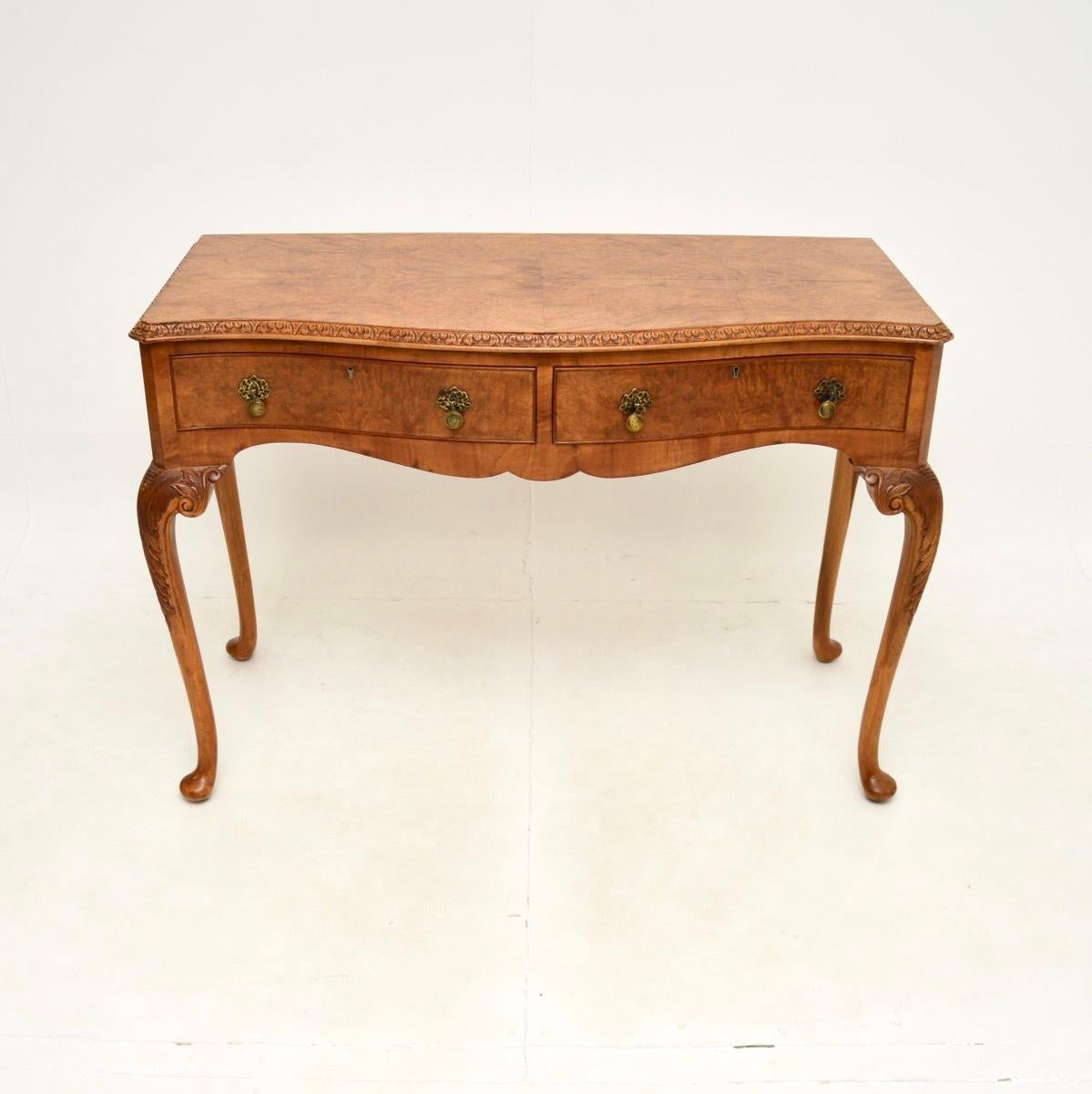 Superbe console / table d'appoint ancienne en ronce de noyer de style Queen Anne. Il a été fabriqué en Angleterre, il date des années 1920-30.

D'une qualité exceptionnelle, il présente de superbes veinures de ronce de noyer et de belles sculptures