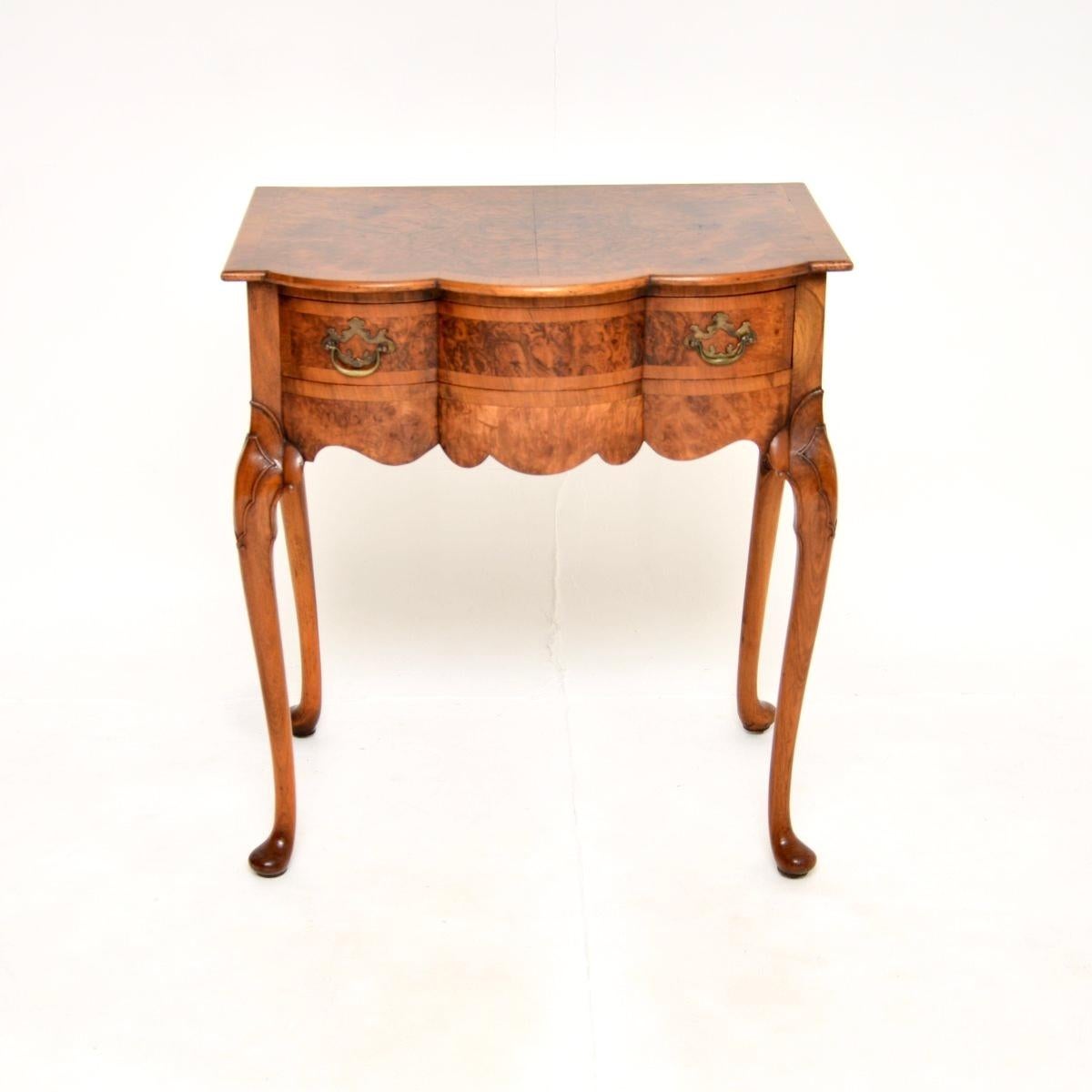A beautiful and elegant antique burr walnut console / side table, made in England and dating from around the 1900-1910 period.

It is of superb quality and is a very useful size, the serpentine top and drawer front have cross banded edges, this sits