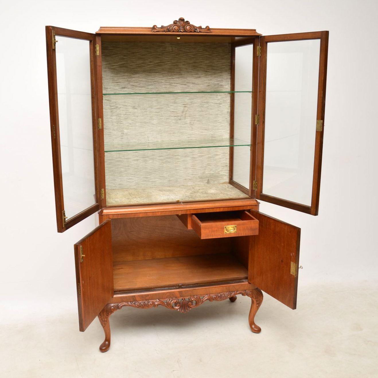 Antique burr walnut display cabinet dating from around the 1920s period & in excellent condition, having just been polished. The display section is lined in a fabric which is still in good condition and has two glass shelves. The bottom section has
