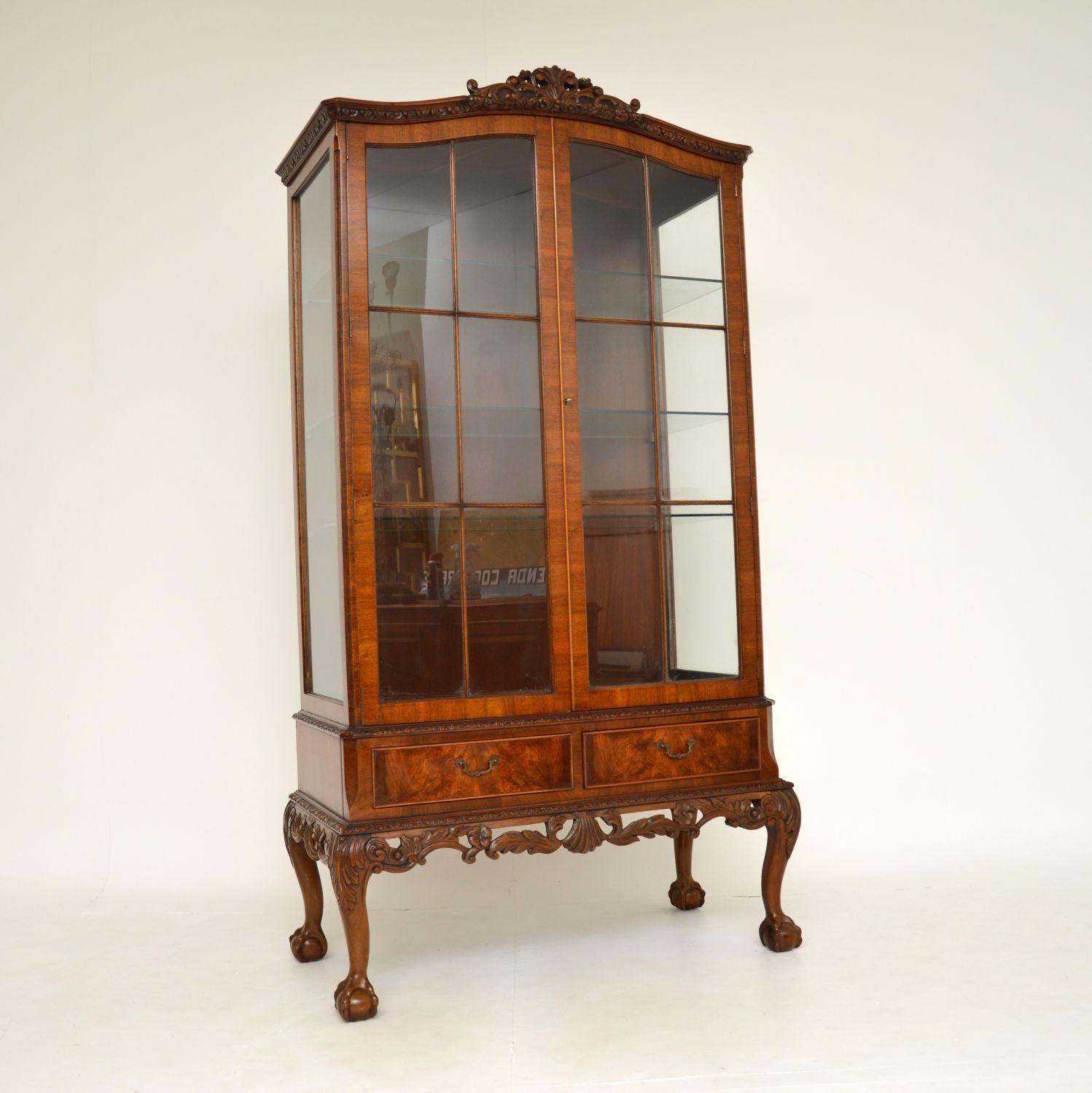 A stunning and impressive antique burr walnut display cabinet in the Queen Anne style, made in England & dating from around the 1930’s period.

This is beautifully made and is of amazing quality. There is excellent, profuse floral carving around