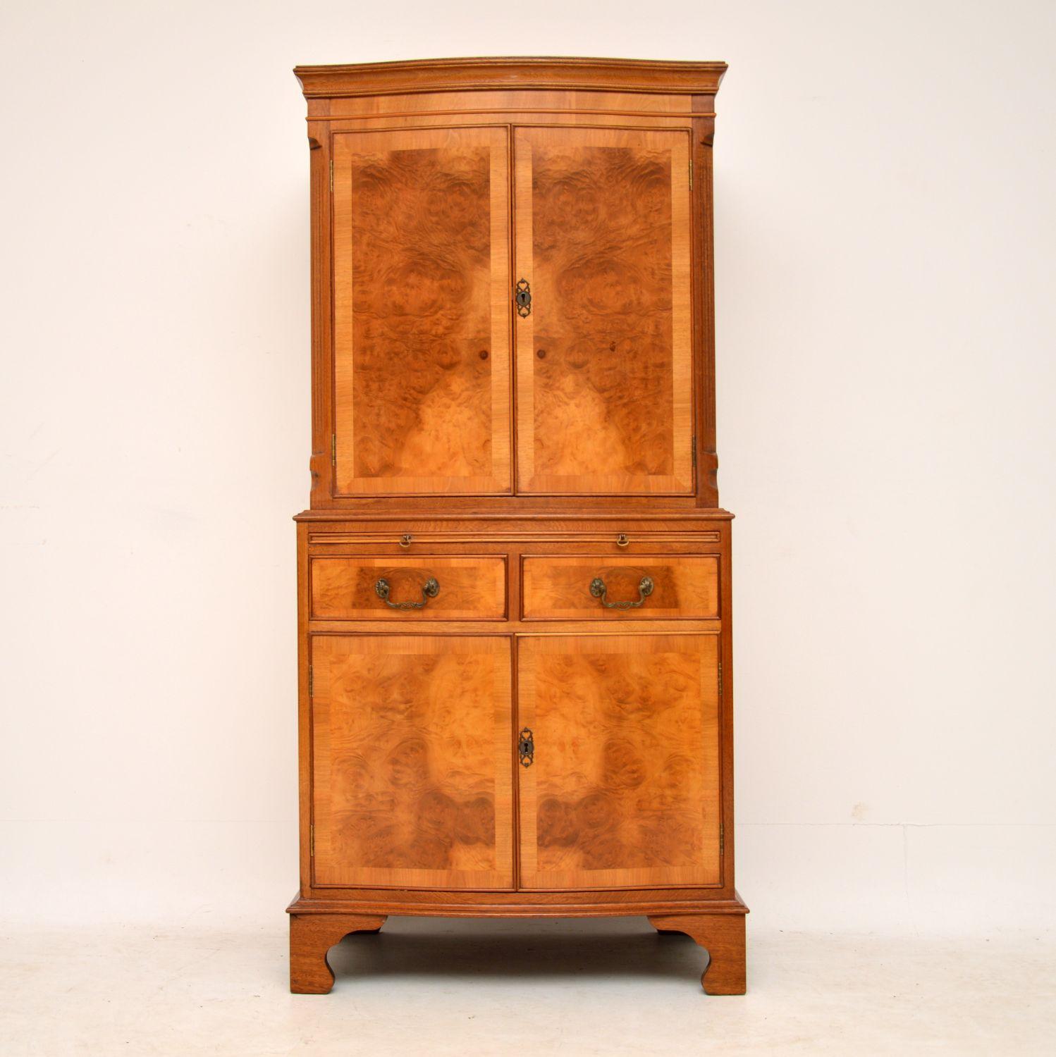 Antique burr walnut drinks cabinet in excellent condition and dating from circa 1930s period. It has a serpentine shaped front, with reeded canted corners on the top section and sits on bracket feet. The pale golden color and the pattern of the burr