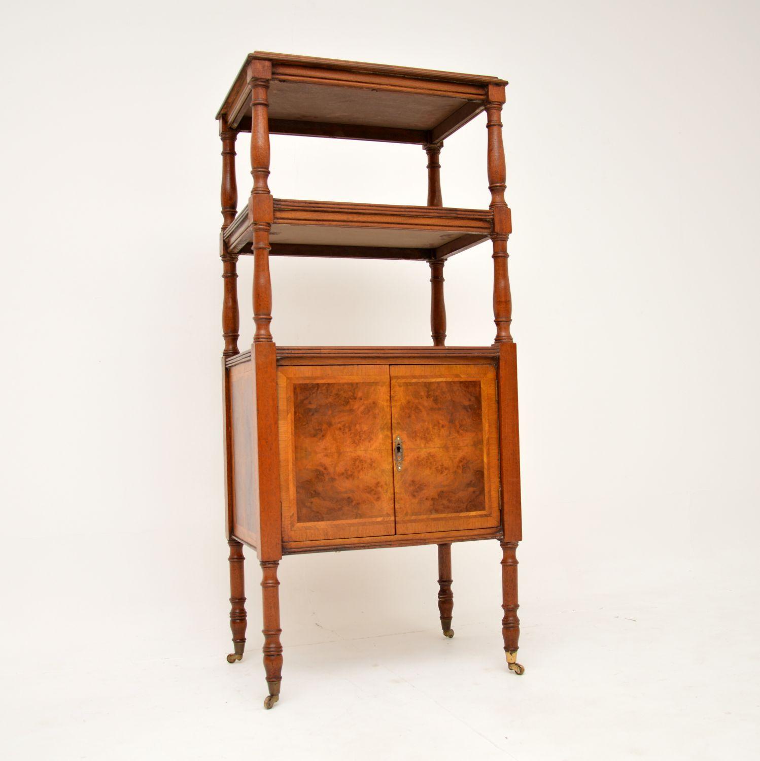 A stunning and useful antique three tier etagere in walnut, with a cabinet below. This was made in England, it dates from around the 1930’s.

The quality is outstanding, with such a high level of craftsmanship on display. The burr walnut grain