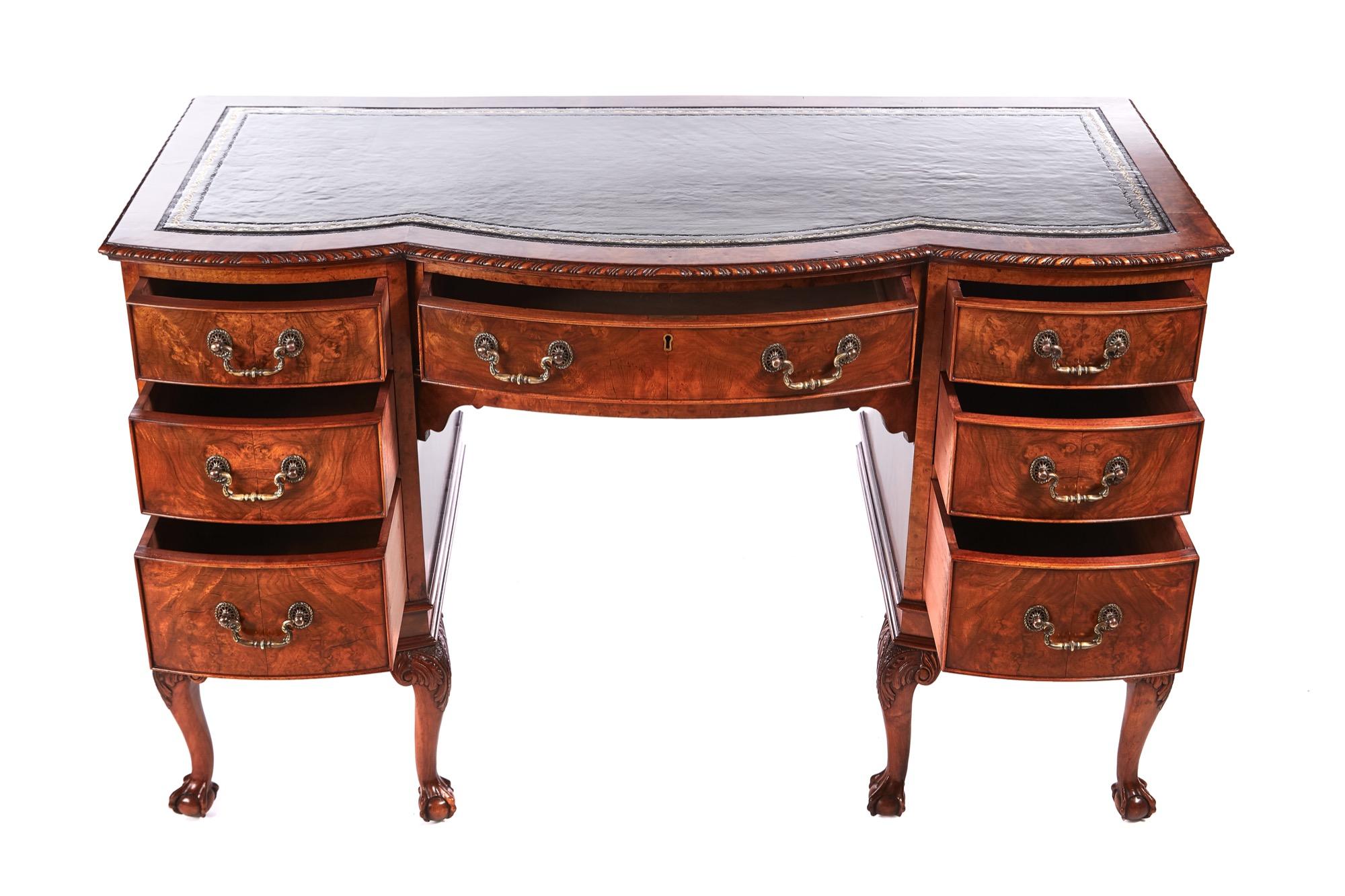 Antique burr walnut freestanding knee hole writing desk having a green leather top, burr walnut cross banding and a carved edge. 7 shaped burr walnut drawers with original brass handles standing on 6 carved cabriole legs with claw and ball