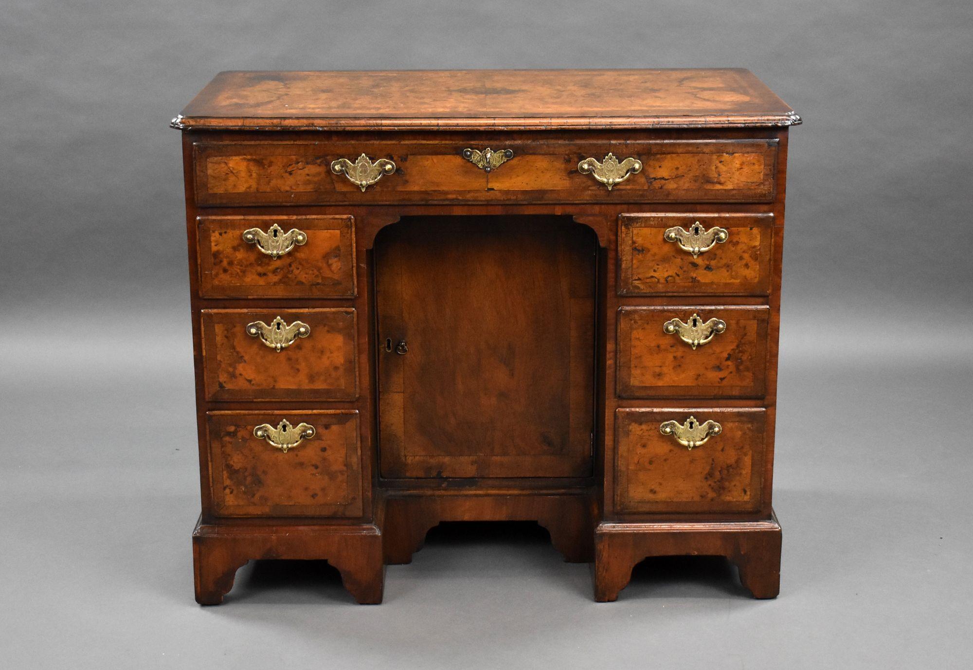 For sale is a good quality antique burr walnut kneehole desk, having a cross banded and quarter veneered top, with cross grain mouldings to the edge, above an arrangement of seven drawers with a cupboard to the centre, each having original brass