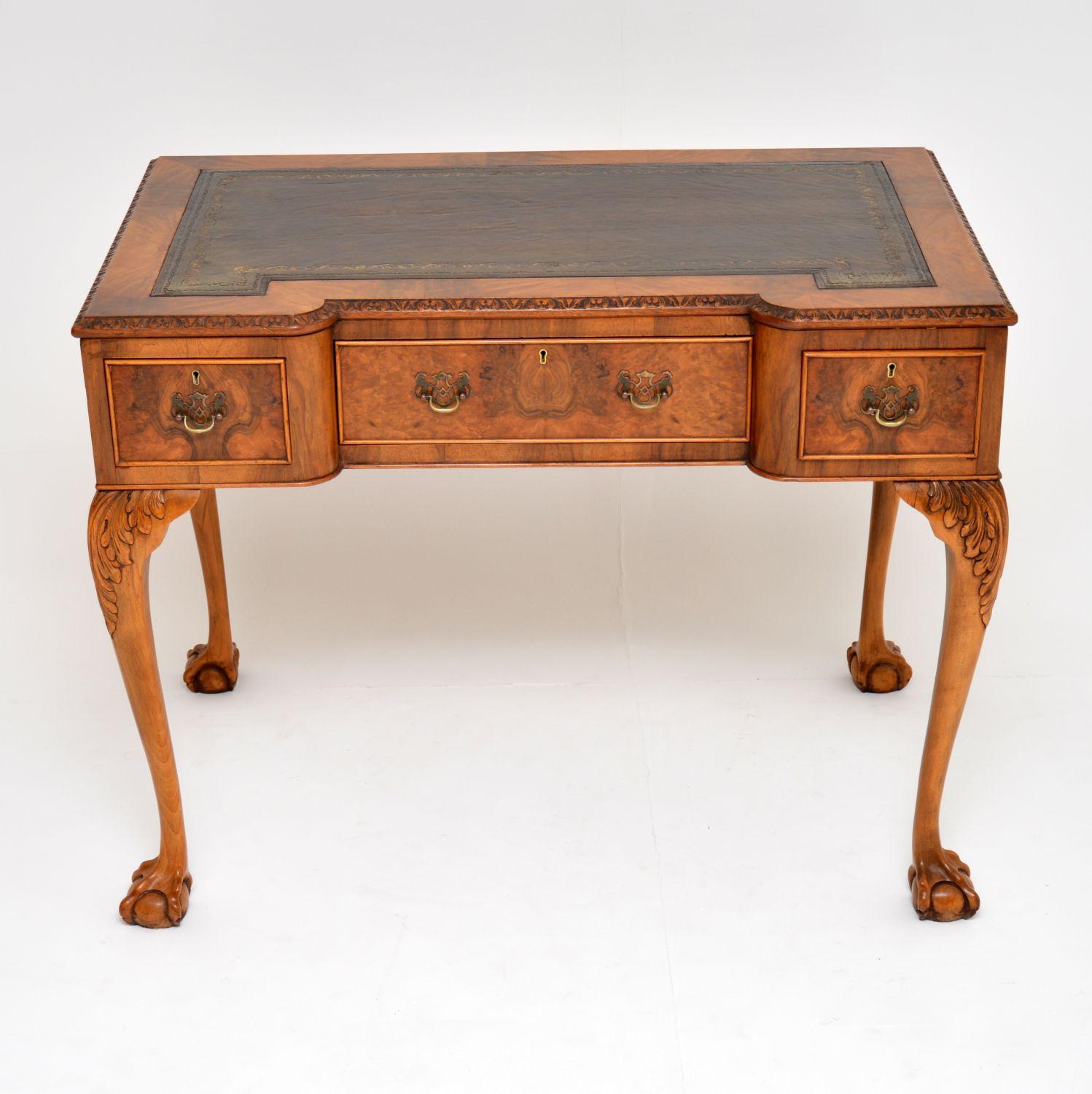 Superb quality and great looking burr walnut antique Queen Anne style desk, dating from the 1920s period and in excellent condition.

It has a hand colored tooled leather writing surface with a carved top edge all the way around. There are three