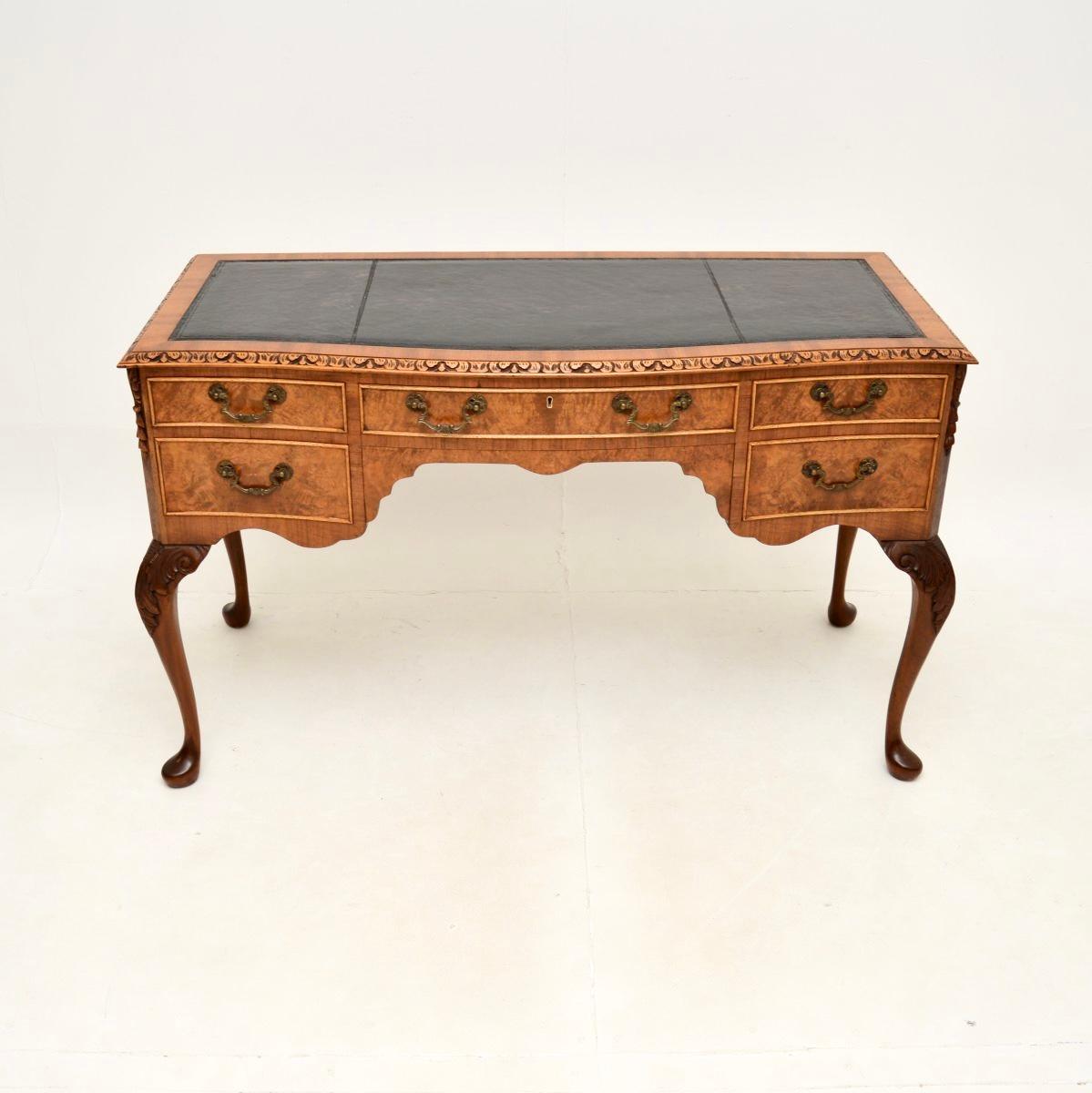 Superbe bureau ancien en ronce de noyer avec dessus en cuir, de style Queen Anne. Il a été fabriqué en Angleterre, il date des années 1930 environ.

Il est d'une superbe qualité, avec des sculptures magnifiques et complexes sur les bords et la base.