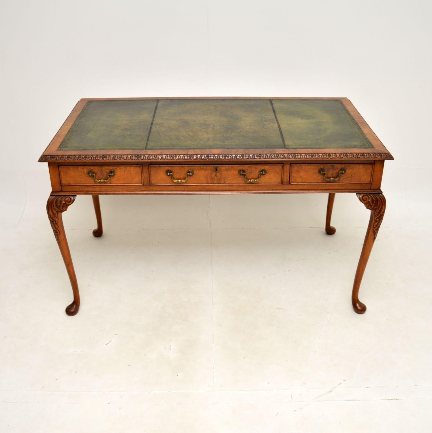Un superbe bureau / table à écrire antique en ronce de noyer avec dessus en cuir. De style Queen Anne, il a été fabriqué en Angleterre et date de la période 1900-1920.

Il est d'une superbe qualité et d'une grande taille, avec beaucoup d'espace de