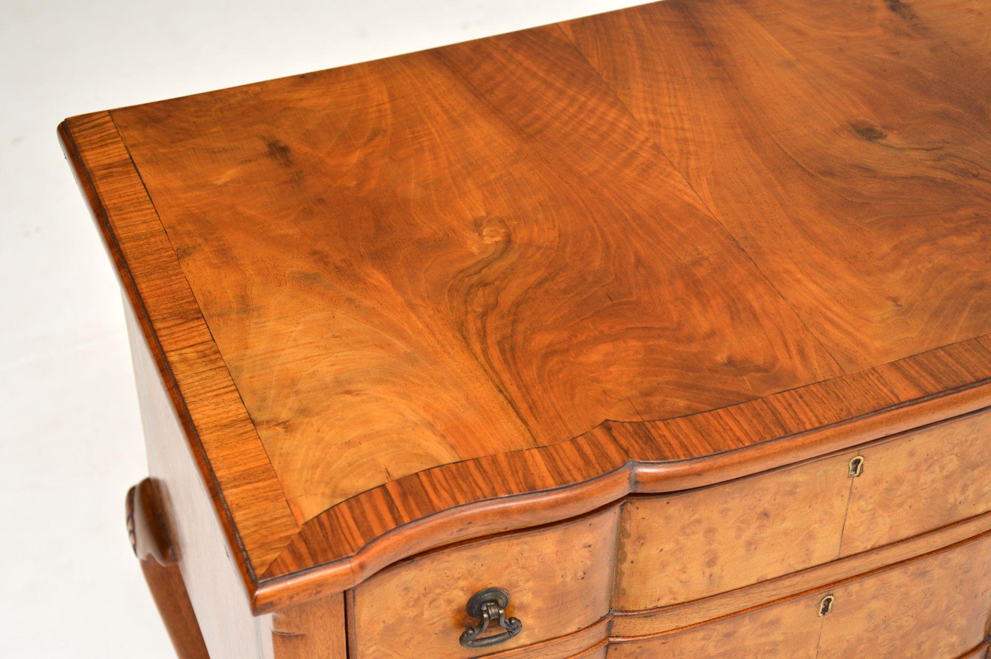 Antique burr walnut lowboy chest with canted corners on solid walnut legs with shell carvings and pad feet. It’s in very good original condition with a lovely warm color and dates to circa 1910s-1920s period. This side table has a shaped front with