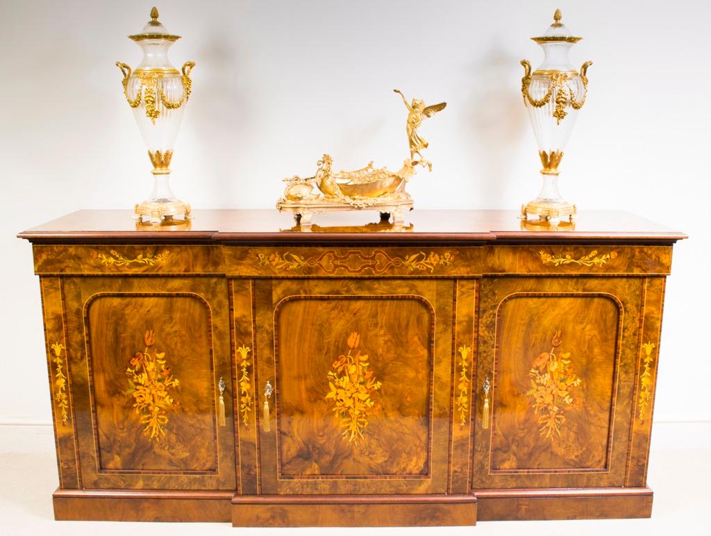 This is a superb antique burr walnut and marquetry breakfront sideboard,  Circa 1920 in date.

It features three capacious drawers above three cupboards, each fitted with a central shelf  with room for all your plates, china, glassware and