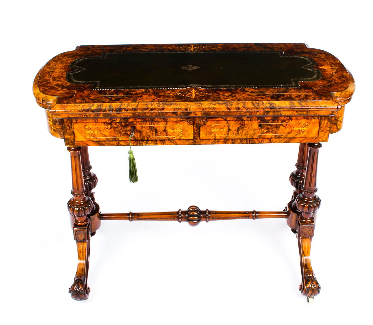 A beautiful antique Victorian burr walnut marquetry inlaid combination writing and card table, circa 1860 in date.

The table has been masterfully crafted from burr walnut with satinwood inlaid marquetry decoration and features a magnificent solid